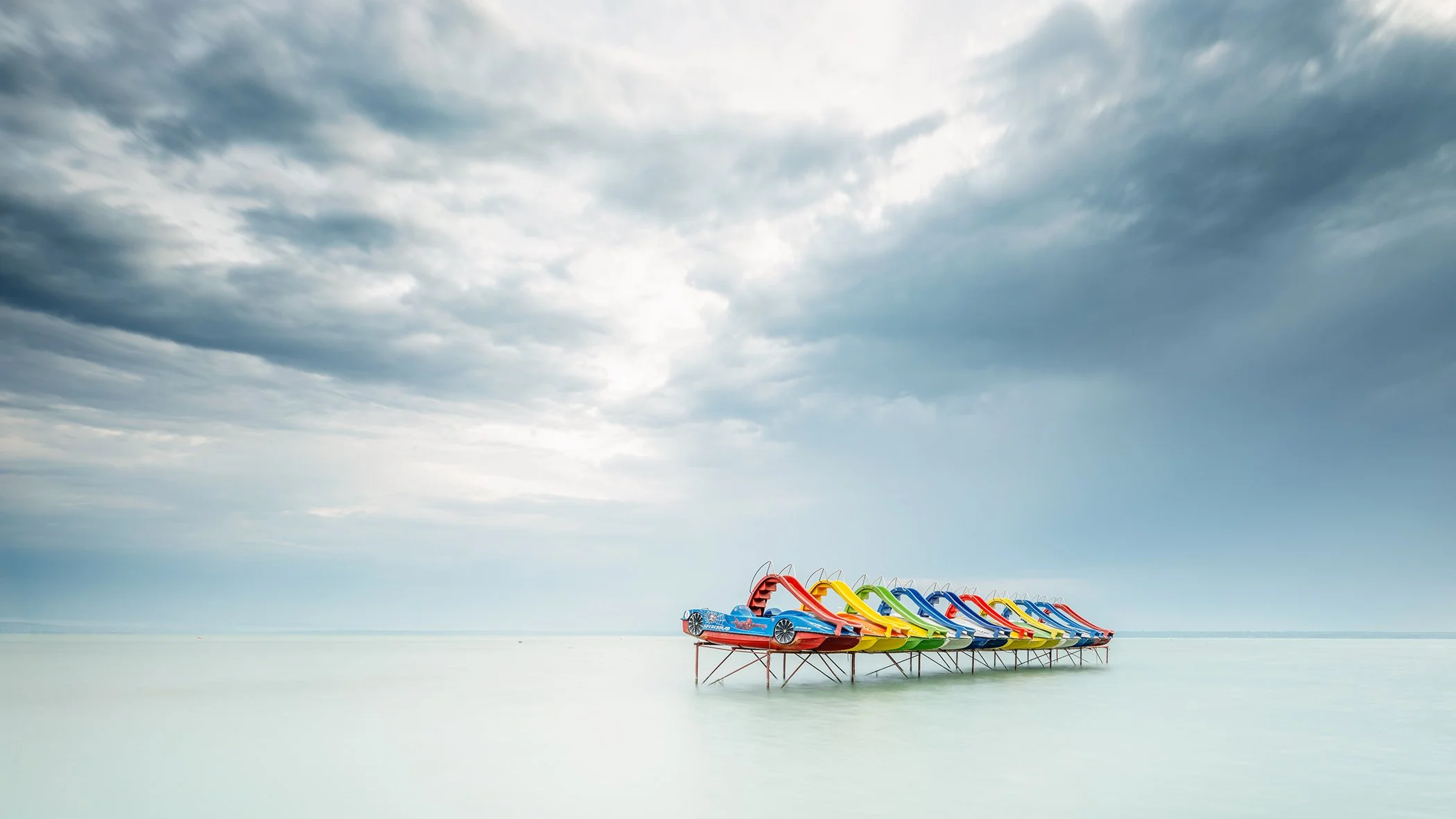 Minimalist panorama of brightly coloured pedal boats on Lake Balaton, Hungary, by Gerald Berghammer.