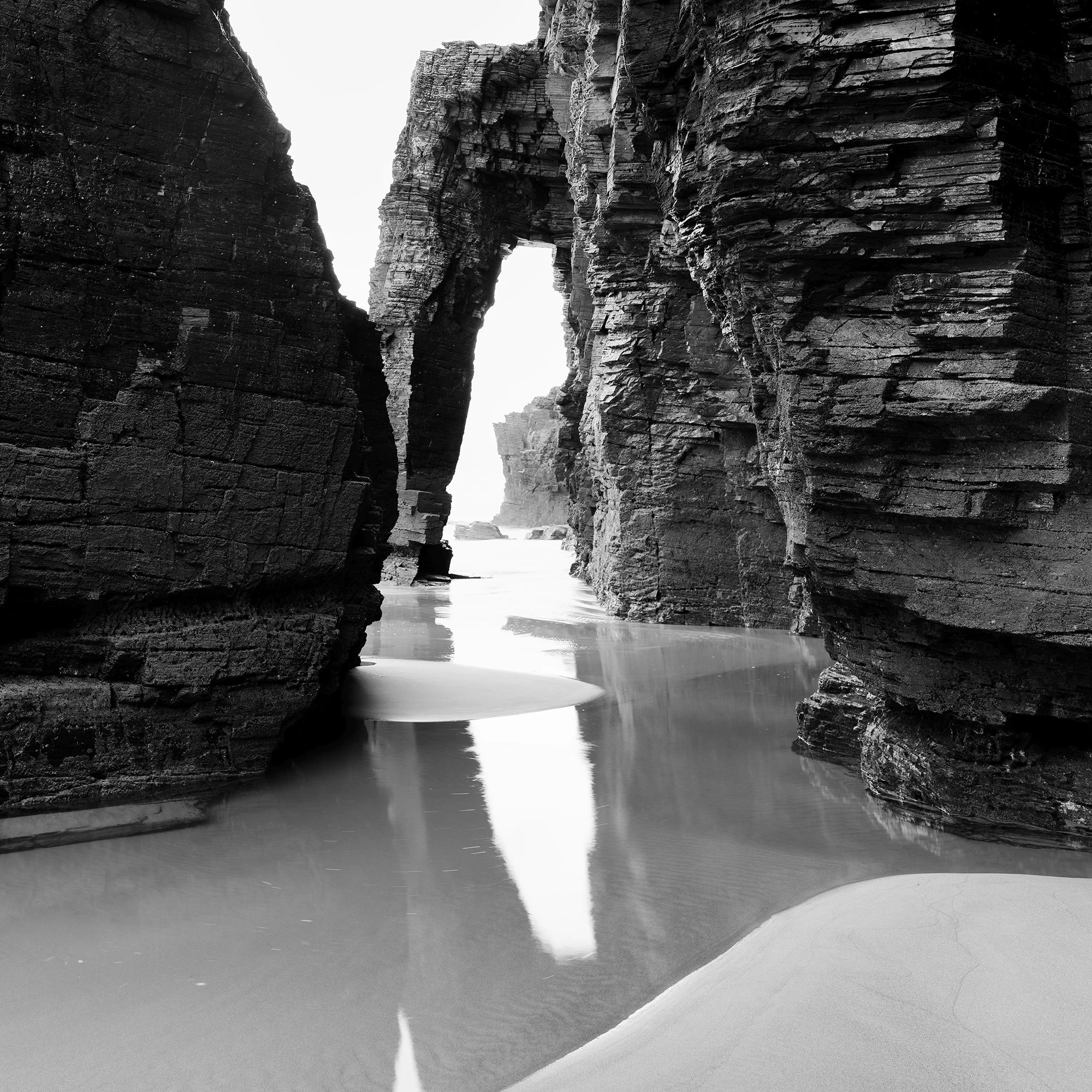Close-up of Arches on Catedrais Beach Study 4 showing the natural rock arch, wet sand and reflections at Praia das Catedrais, Spain.