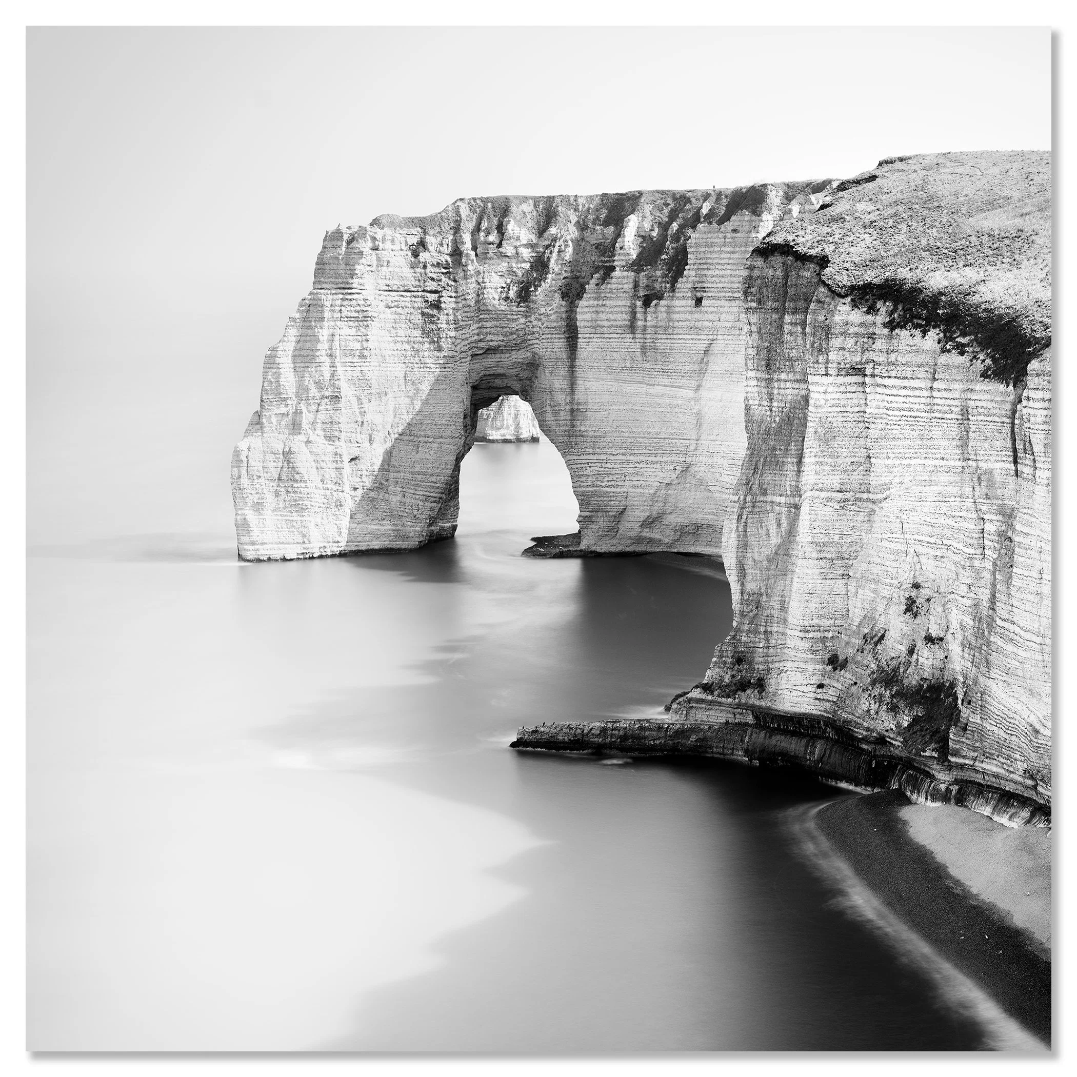 Black and white minimalist seascape photo of a natural rock arch over the water on a rugged coastline – dibond frameless
