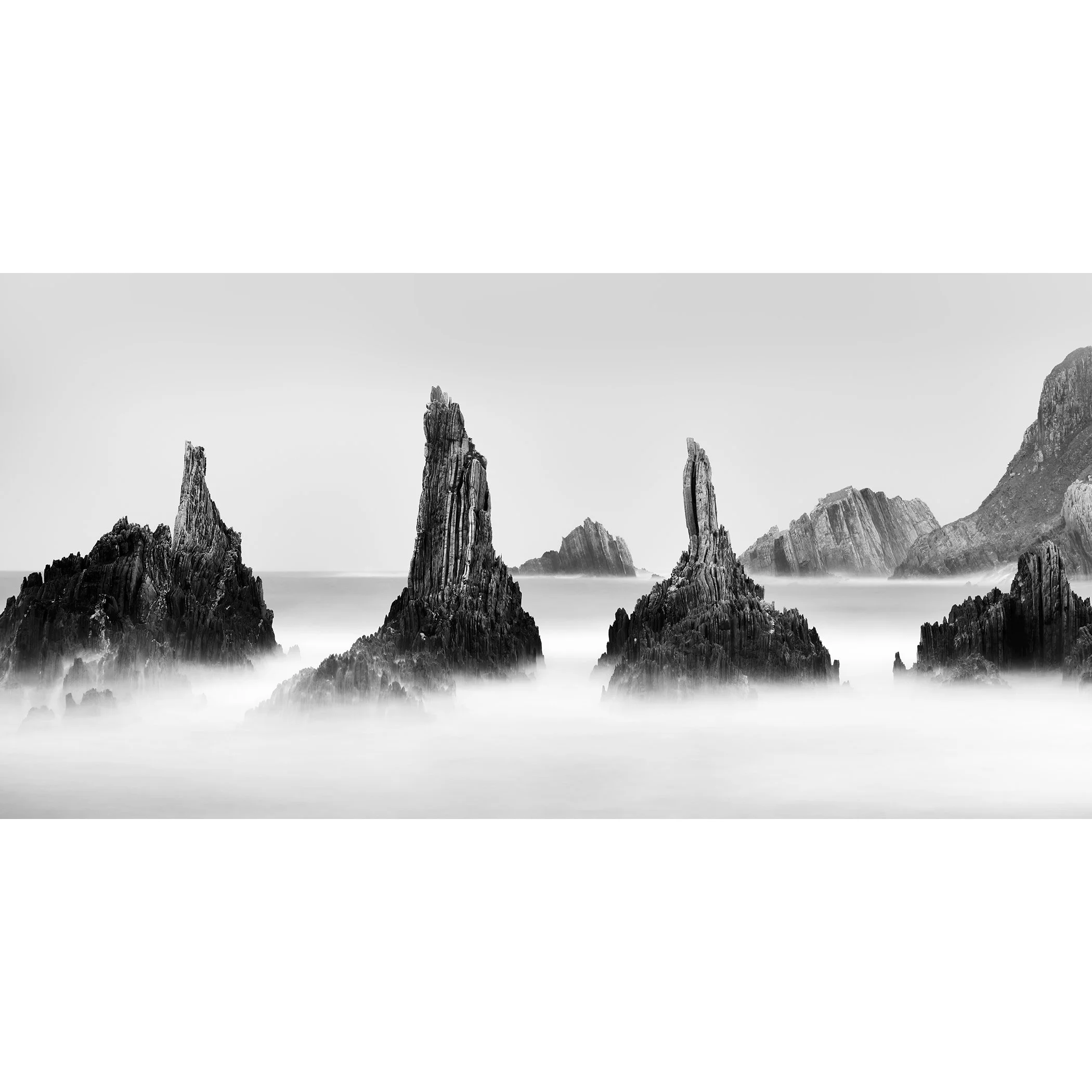 Rocky Peaks Panorama Study 5 by Gerald Berghammer, panoramic black-and-white long-exposure seascape with jagged rock formations on Spain’s Atlantic coast.