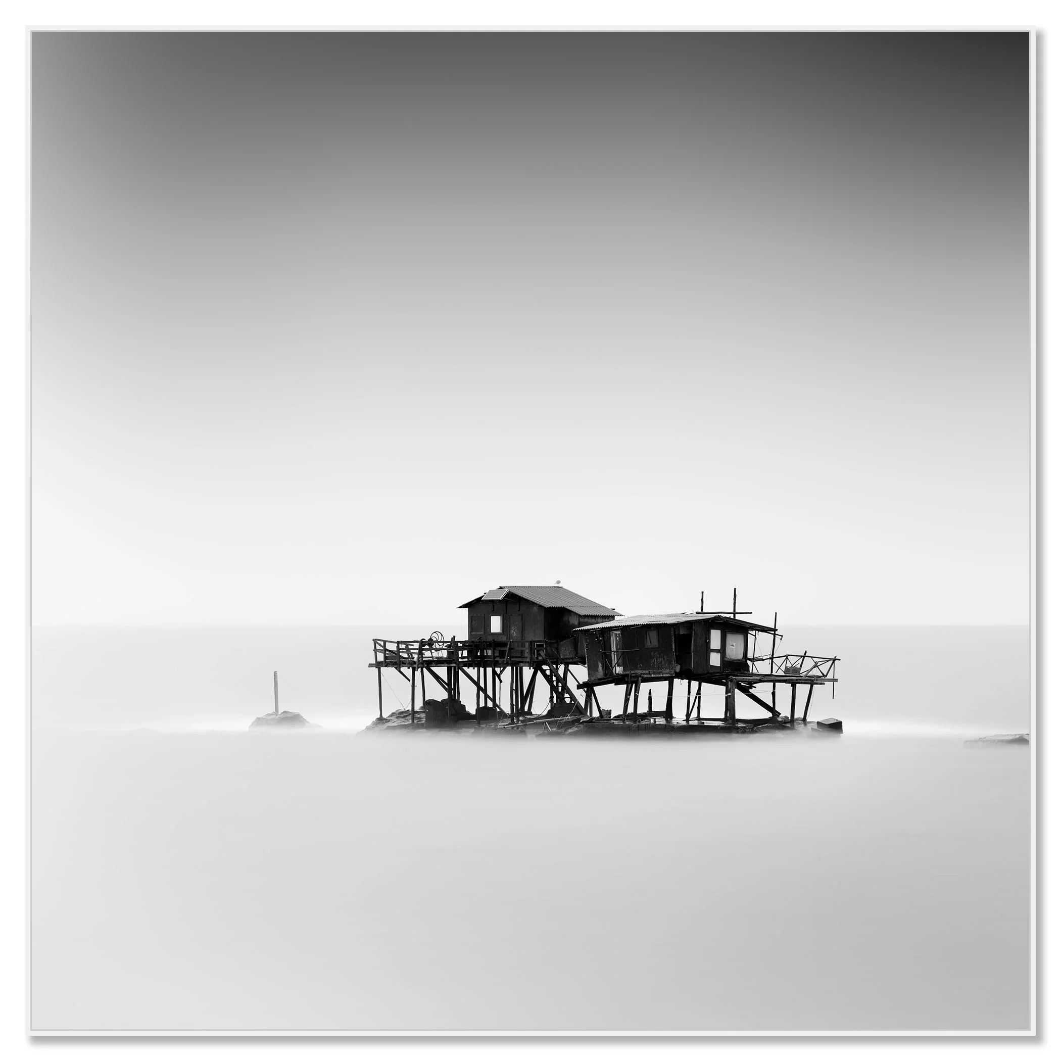 Monochrome fine art photograph of fishing huts on stilts in the sea off Marina di Pisa, Tuscany – framed ArtBox white