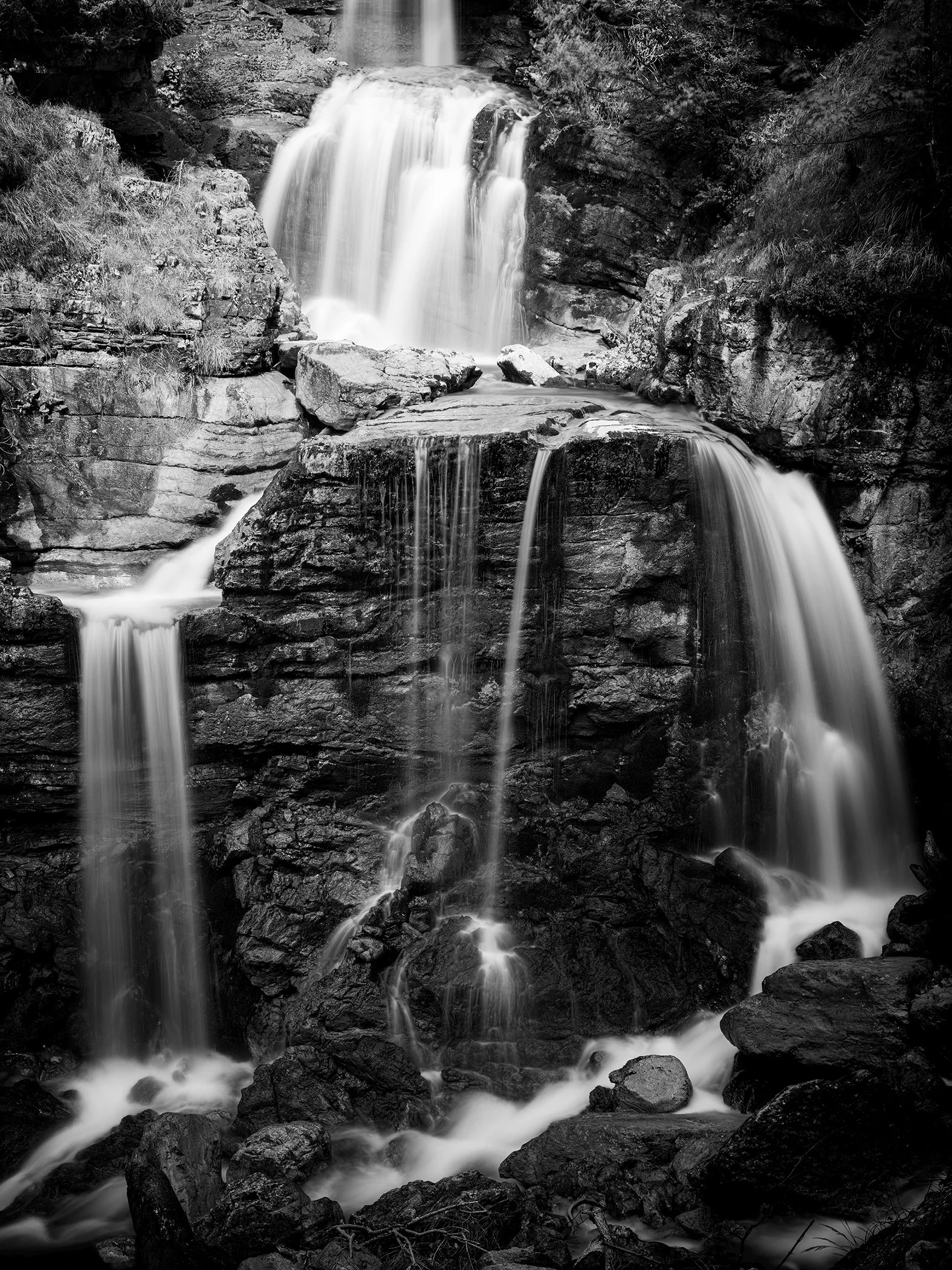 Black-and-white long-exposure photograph of the Lower Kuhflucht Waterfall cascading over rugged rocks in Germany, by Gerald Berghammer.