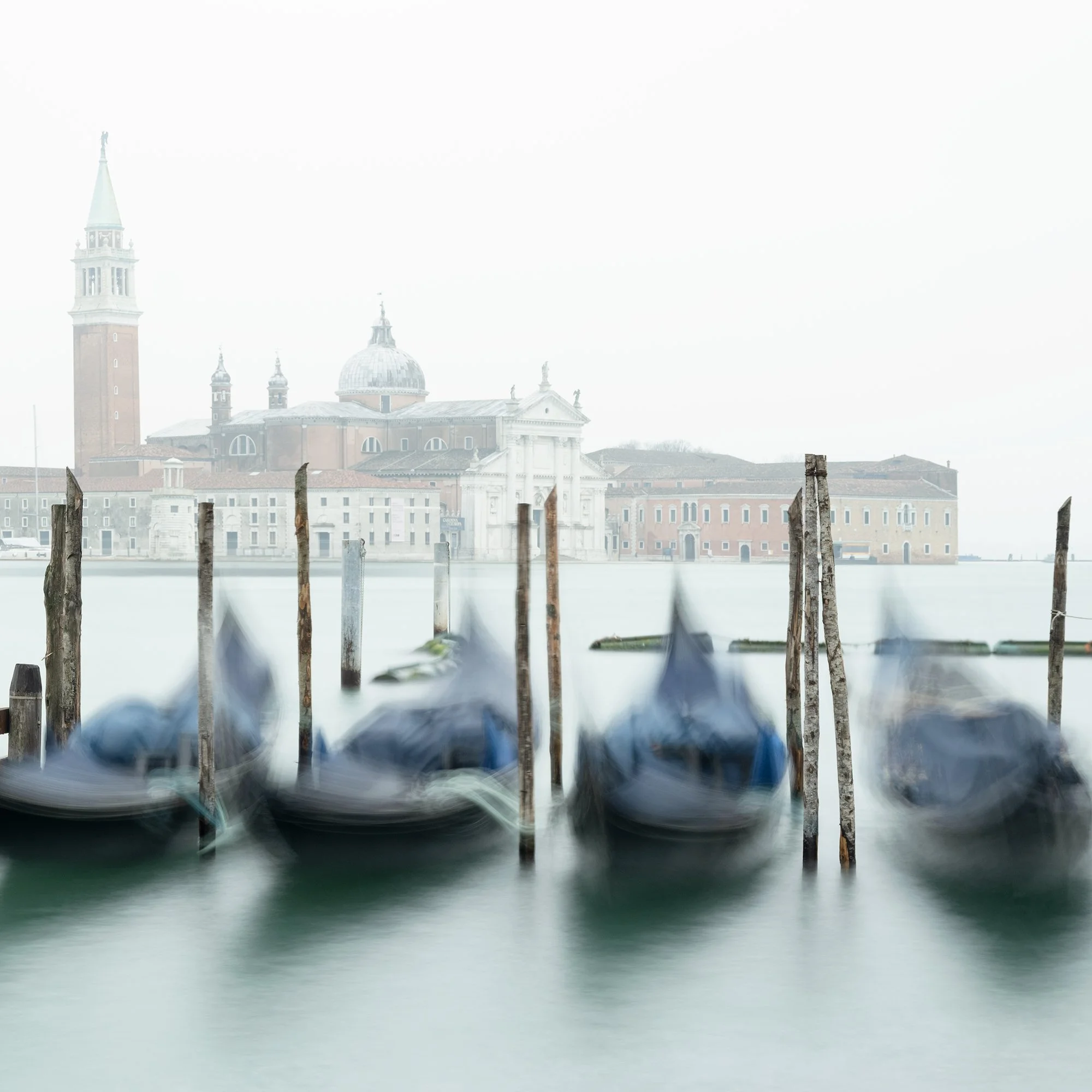 Gerald Berghammer - Color cityscape photography. Gondolas docked along wooden posts on a misty water canal and in back San Giorgio Maggiore Church. Print detail 2