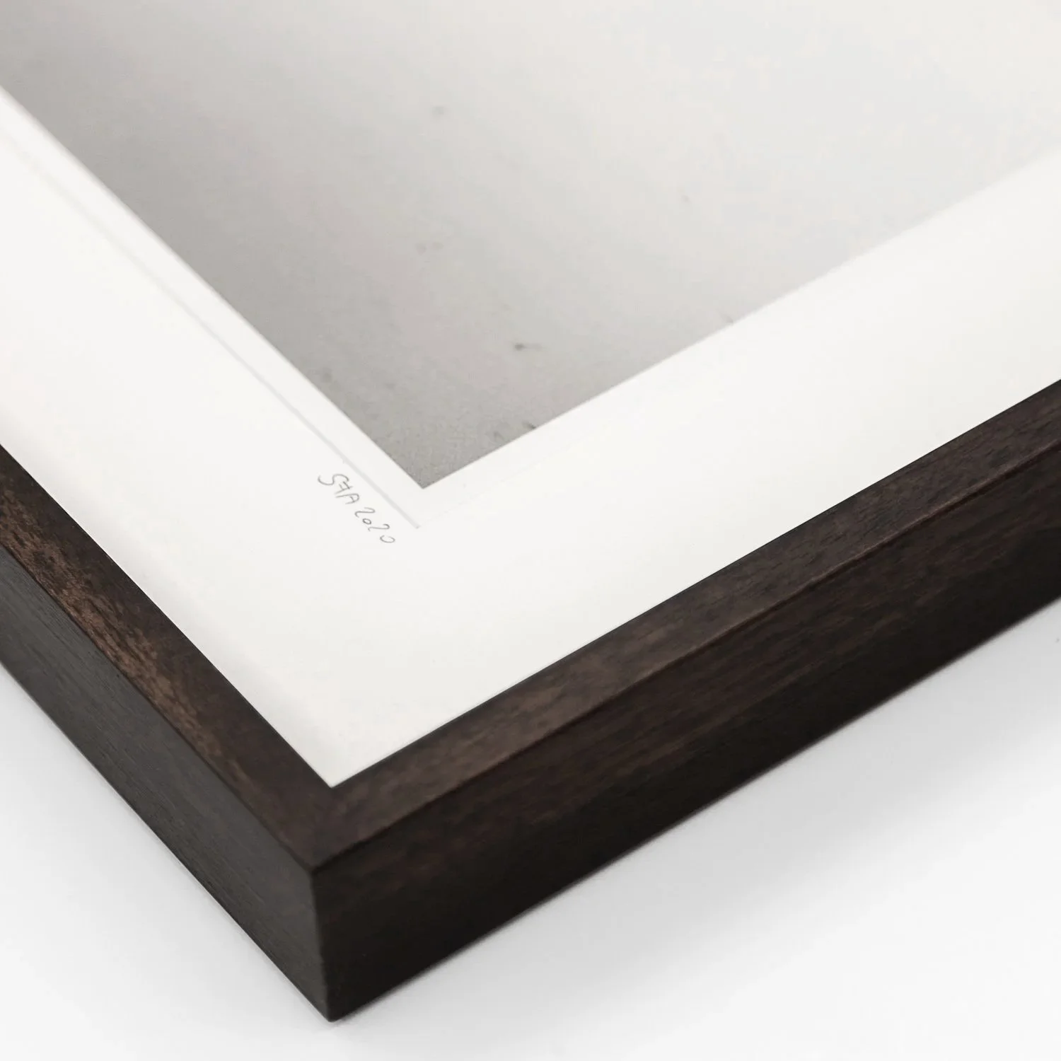 Detail of the dark-brown wooden frame, archival mount and handwritten inscription on Gerald Berghammer's exhibited photograph.