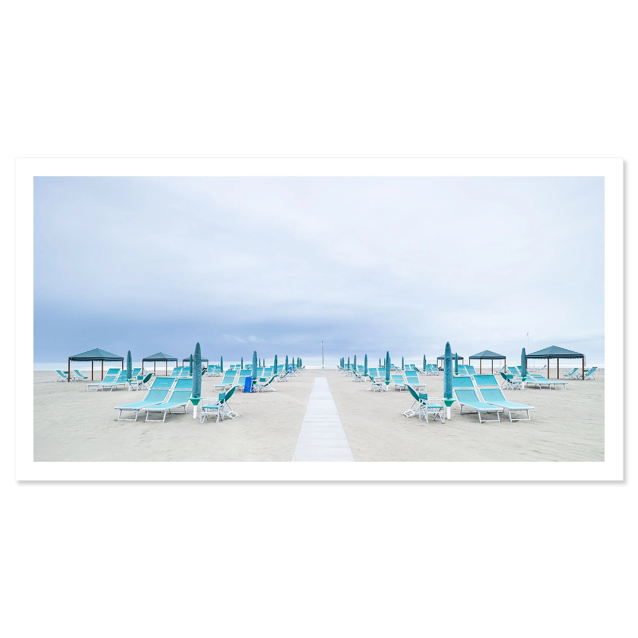 Gerald Berghammer - Color panorama landscape photography. Empty beach with blue lounge chairs, umbrellas, and gazebos on sand under a cloudy sky. Fine art print only