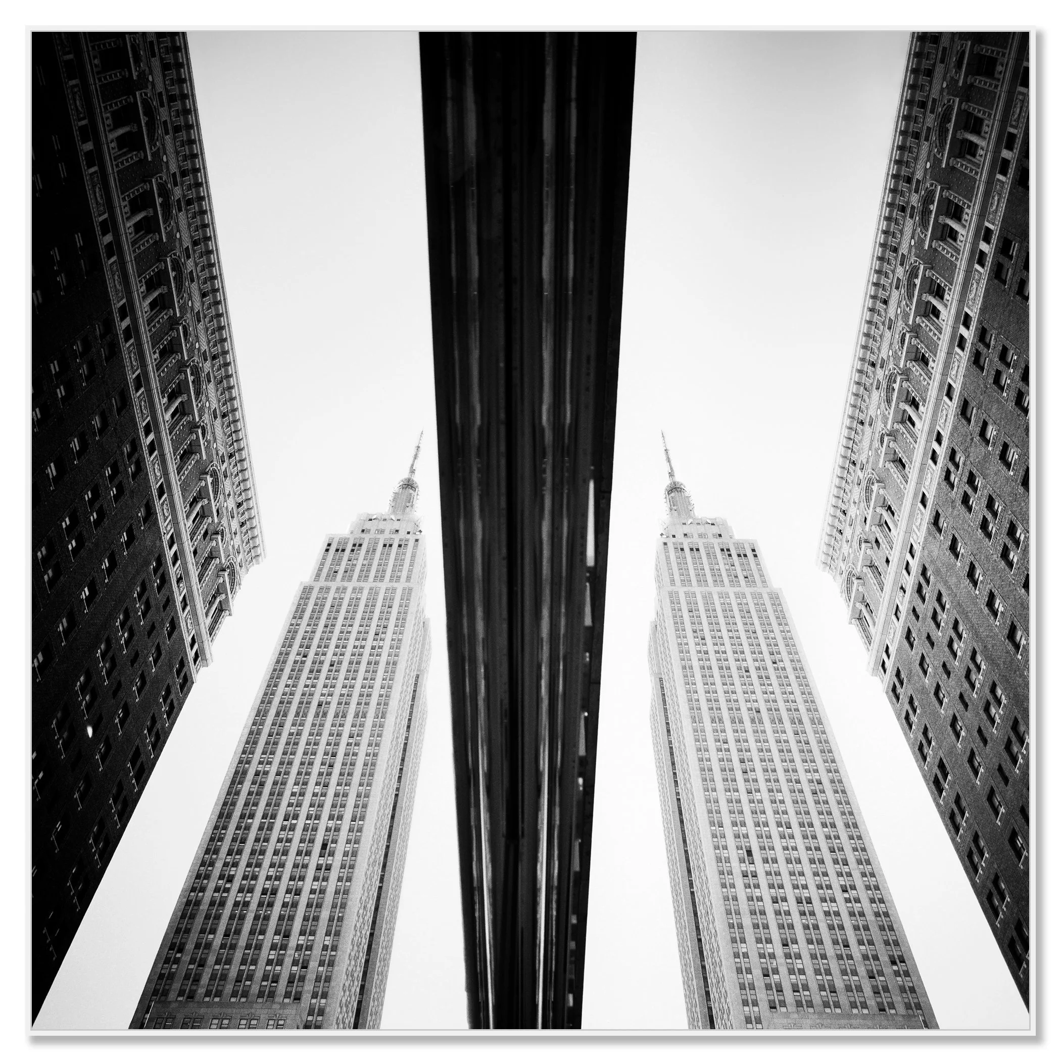 Low-angle black-and-white photograph of symmetrical skyscrapers in New York City – framed ArtBox white