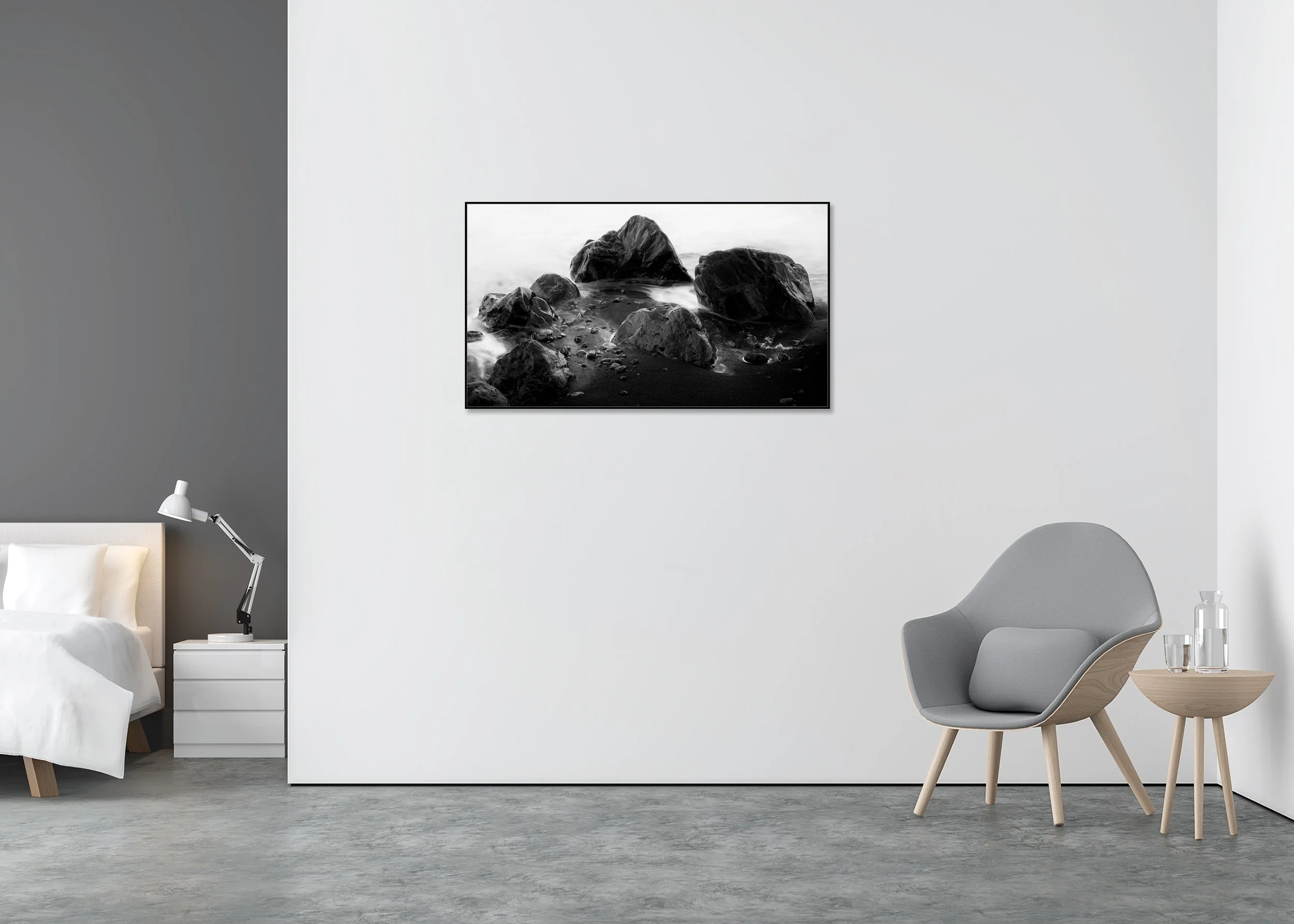 Monochrome coastal wall art print with dark shoreline rocks, smooth water and black sand, mounted to Dibond in a slim aluminium ArtBox frame
