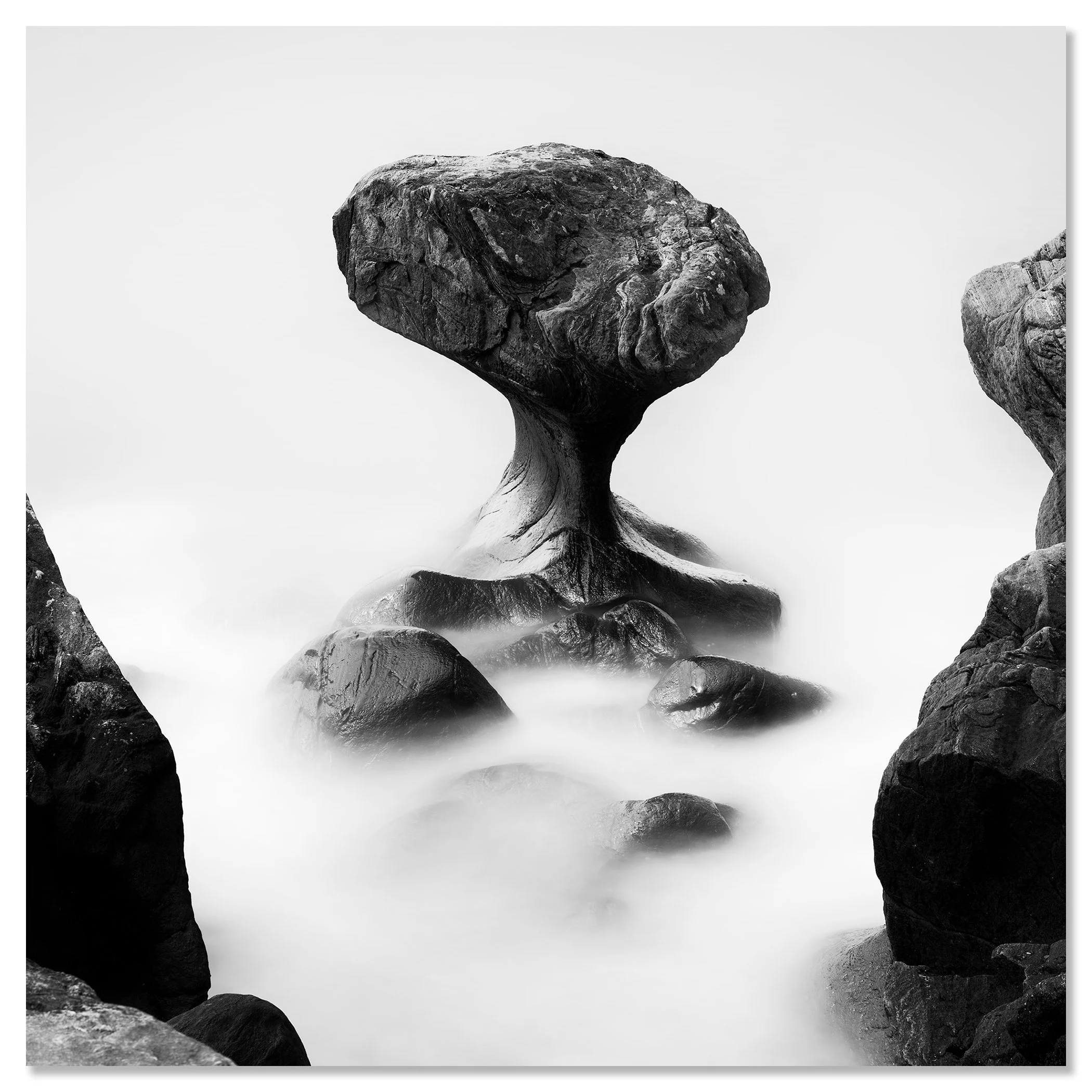 Fine art monochrome image of an eroded sea stack in calm foggy water – dibond frameless