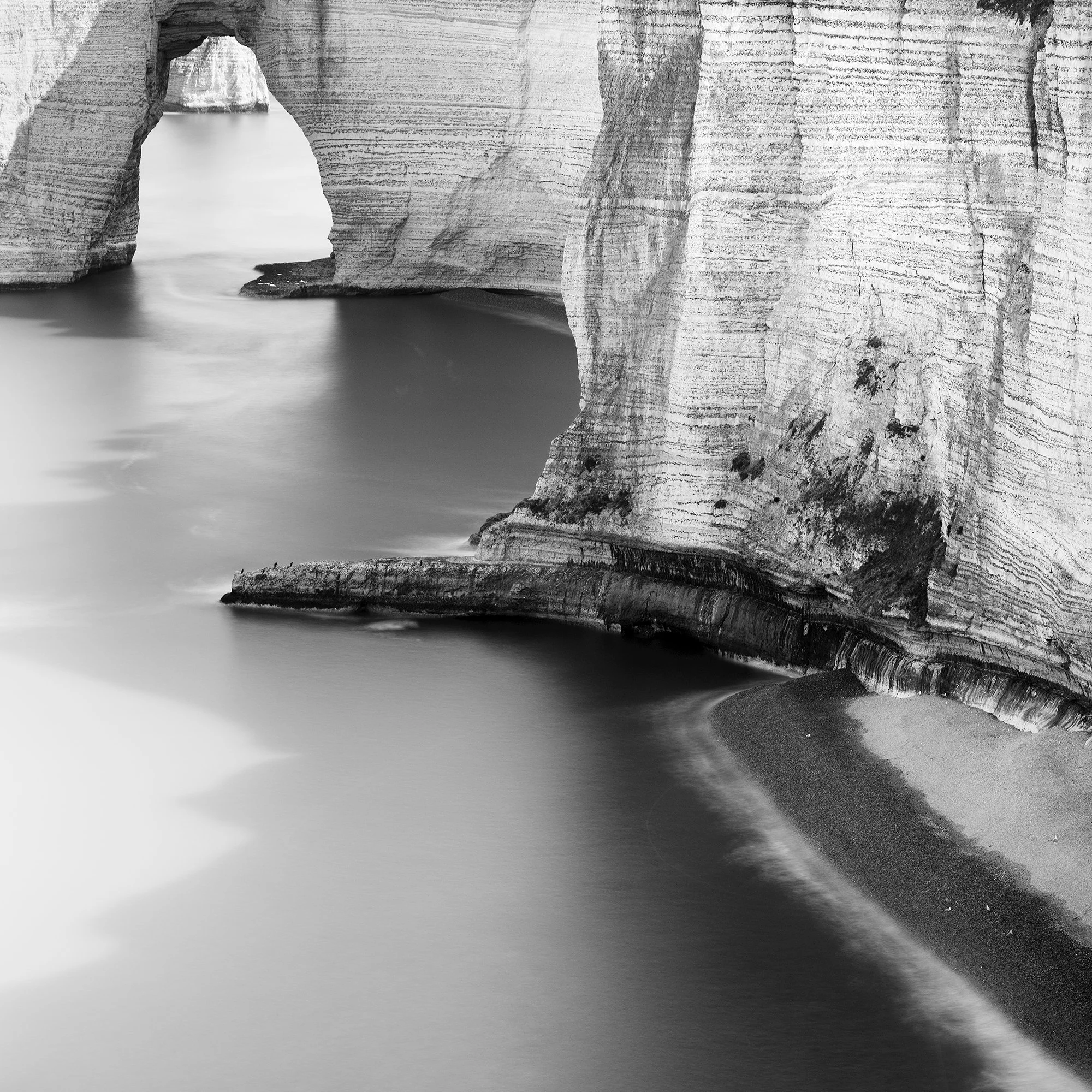 Detail of Alabaster Coast Study 1 by Gerald Berghammer, showing the textured chalk cliff, dark beach and smooth long-exposure seawater.