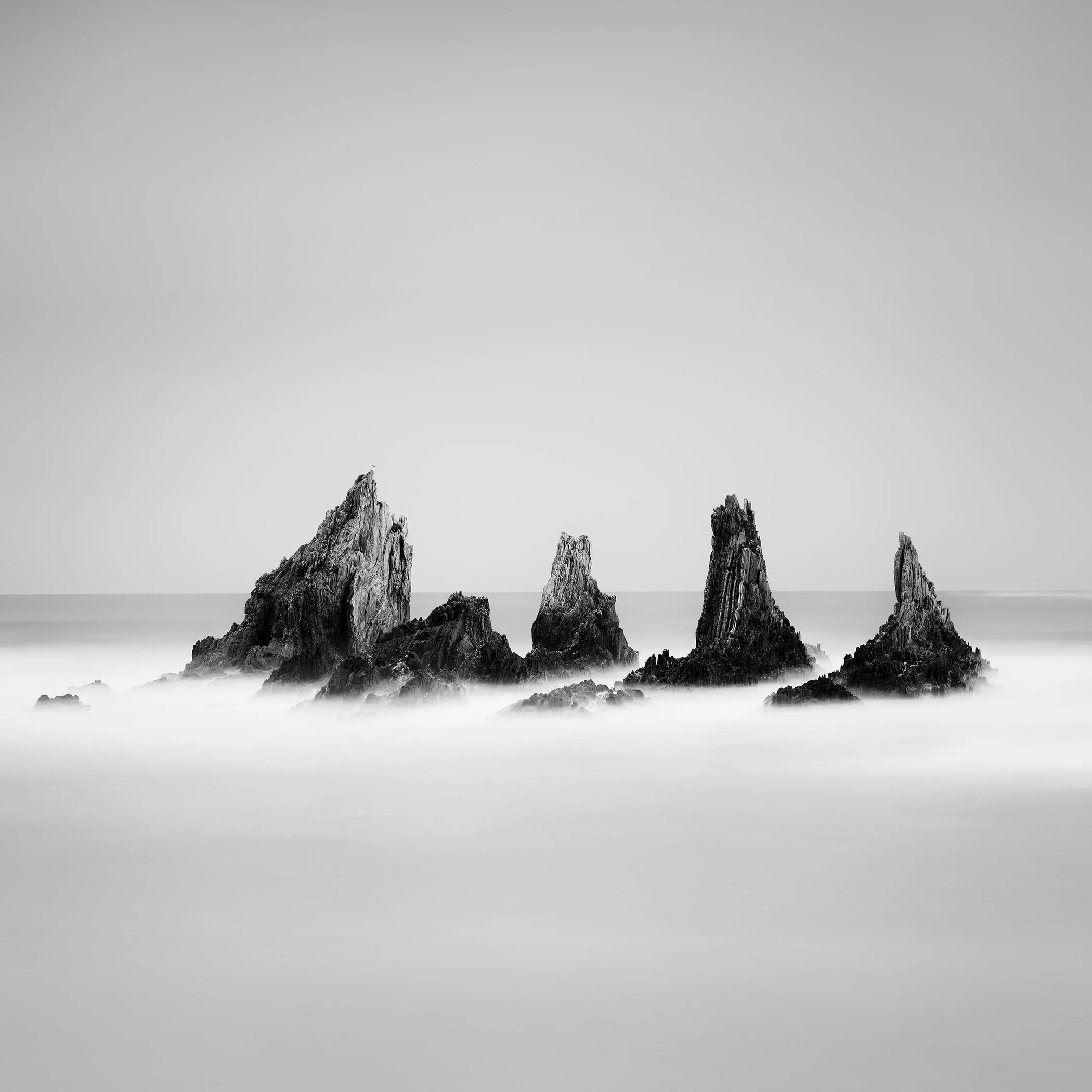 Rocky Peaks Study 1 by Gerald Berghammer, minimalist black-and-white long-exposure seascape of jagged sea stacks on Spain’s Atlantic coast.