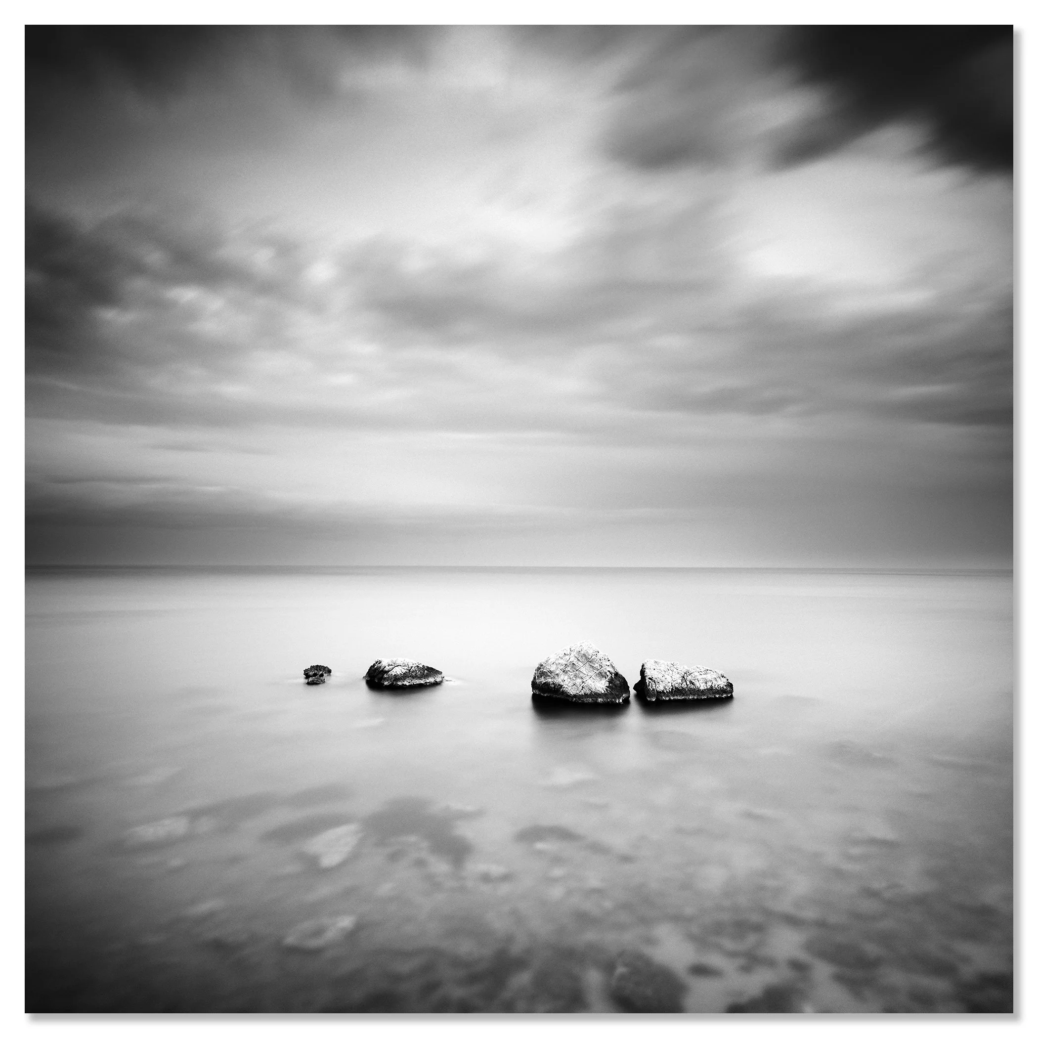 Black-and-white minimalist long-exposure seascape with rocks in calm ocean, soft horizon – dibond frameless