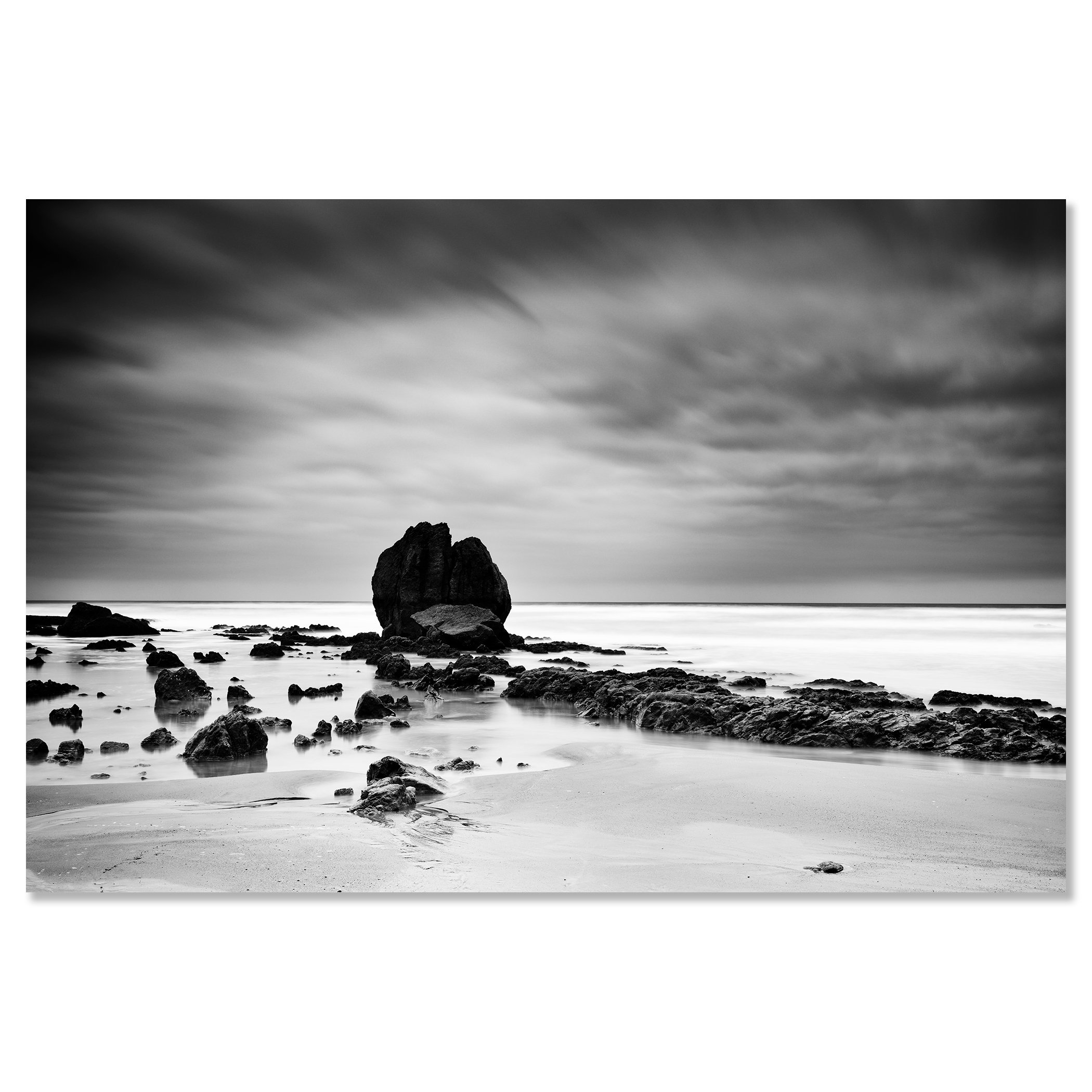 Long-exposure monochrome photo of a rocky beach, soft waves and overcast sky creating a moody seascape – dibond frameless