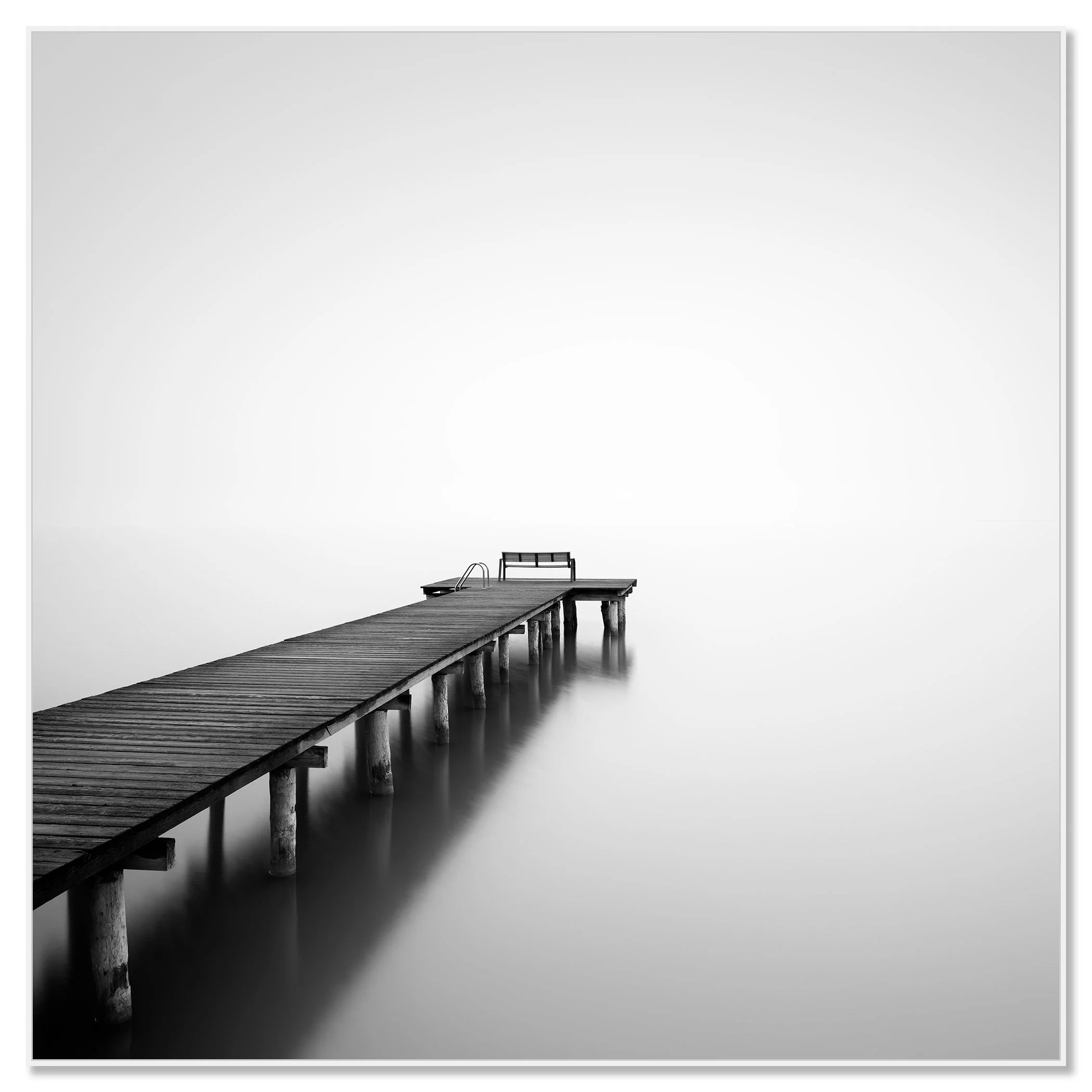 Minimalist black-and-white photo of a wooden pier fading into mist over calm water – framed ArtBox white