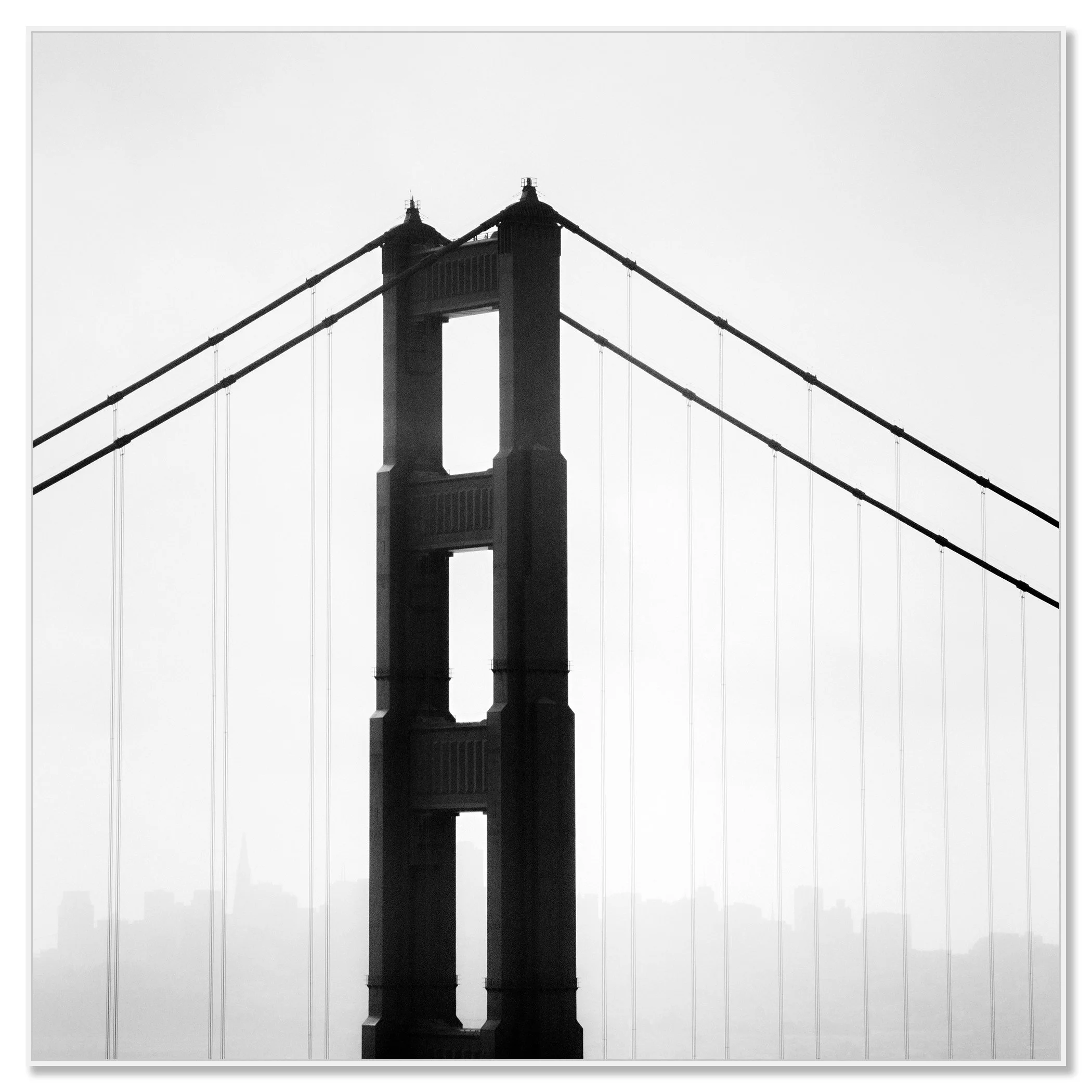 © 2015 Gerald Berghammer - Black and white photo. Golden Gate Bridge in San Francisco, seen from the side, with the city skyline faintly visible in the background. Chromaluxe framed white