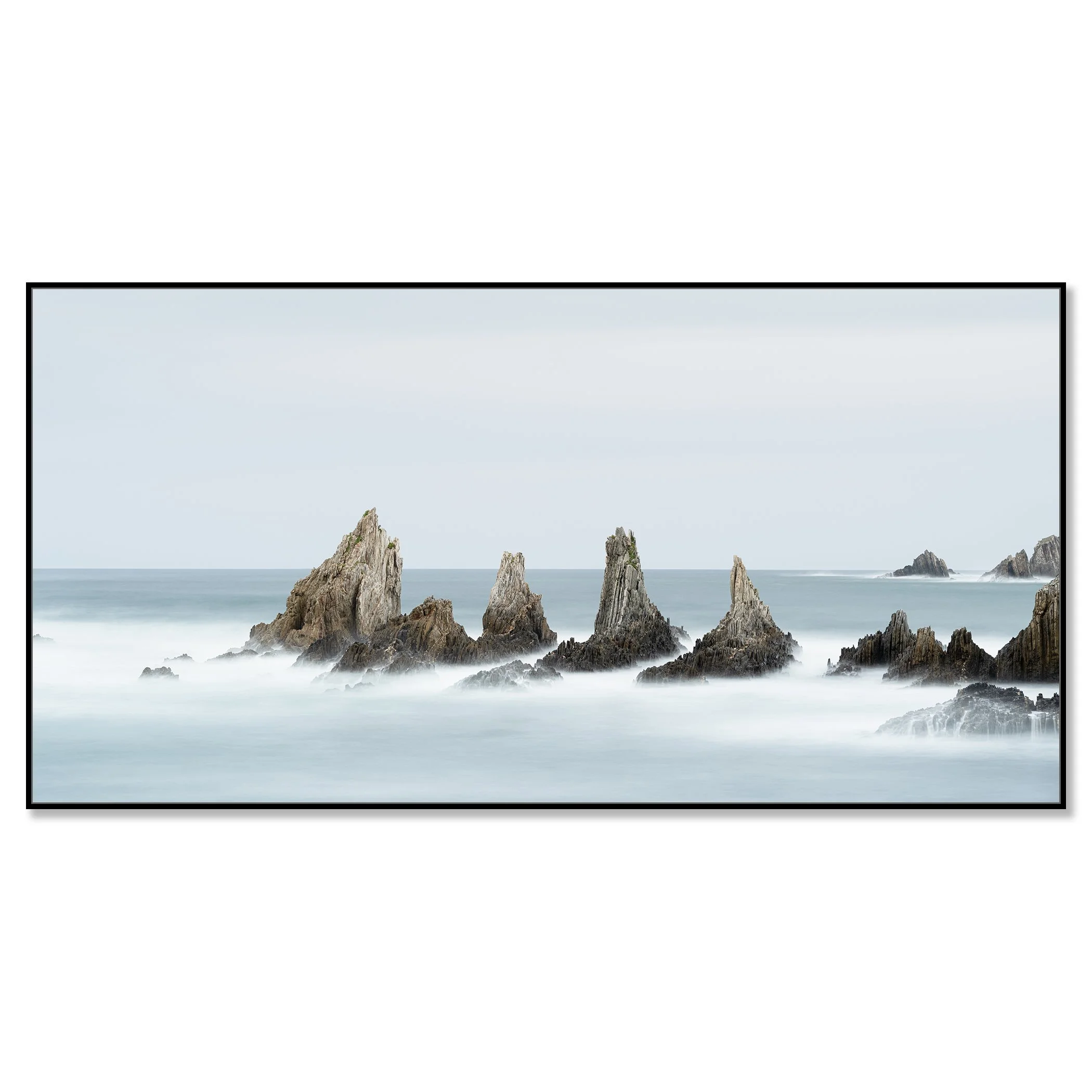Long exposure minimalist seascape photo of jagged ocean rocks with misty water and cloudy sky – framed ArtBox black
