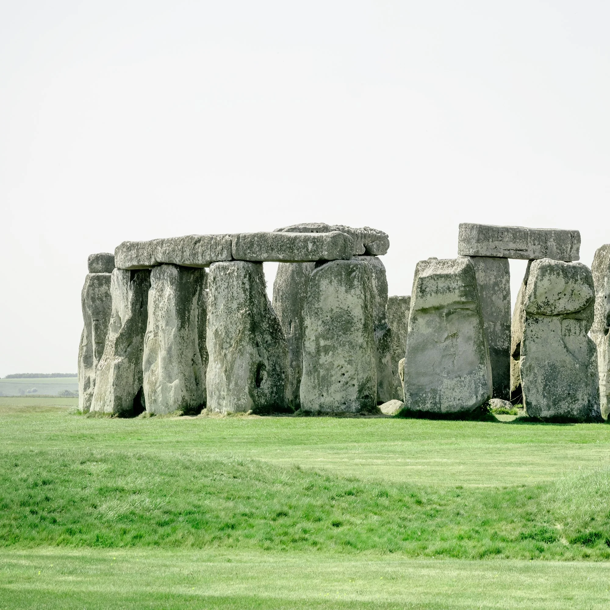 Gerald Berghammer - Color landscape panorama photography. Historic Stonehenge monument with large standing stones on a grassy field under a gray sky. Print detail 1