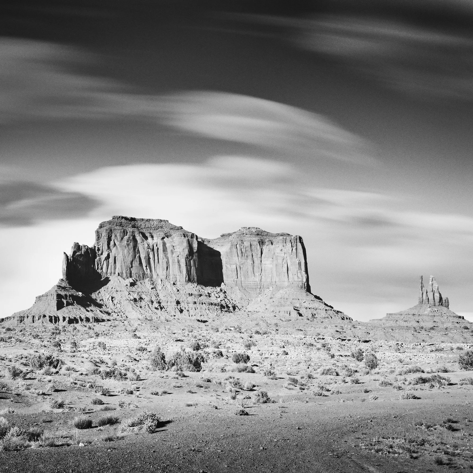 © 2015 Gerald Berghammer - Black and white photography. Landscape of rugged desert terrain with large rock formations and scattered vegetation under a cloudy sky. Print detail 3