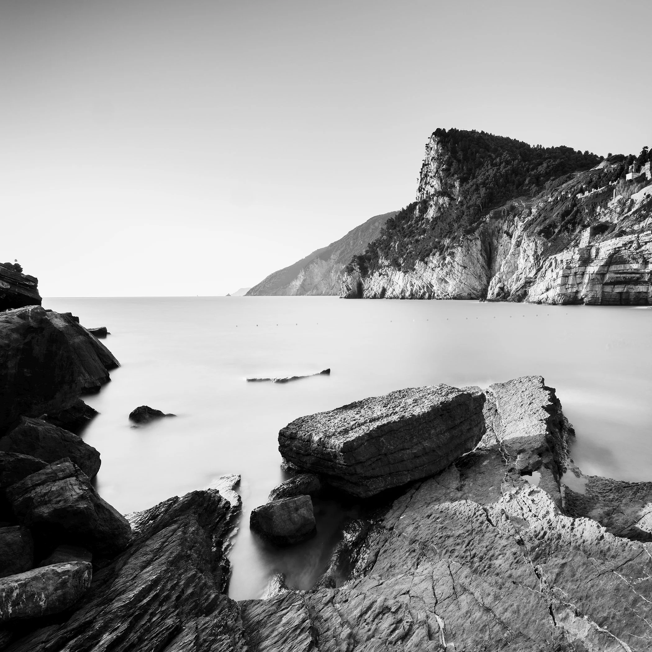 Black-and-white long-exposure photograph of the rocky coast of Porto Venere, Italy, by Gerald Berghammer.
