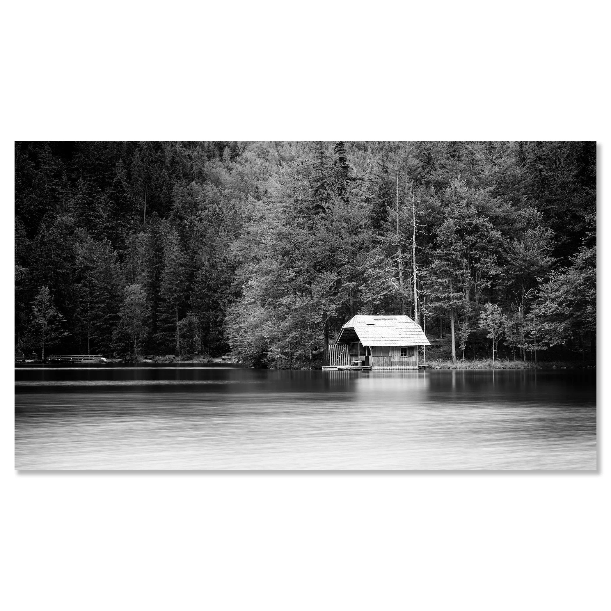 Calm lake in black and white with a small boathouse, wooden jetty and trees along the shore – dibond frameless