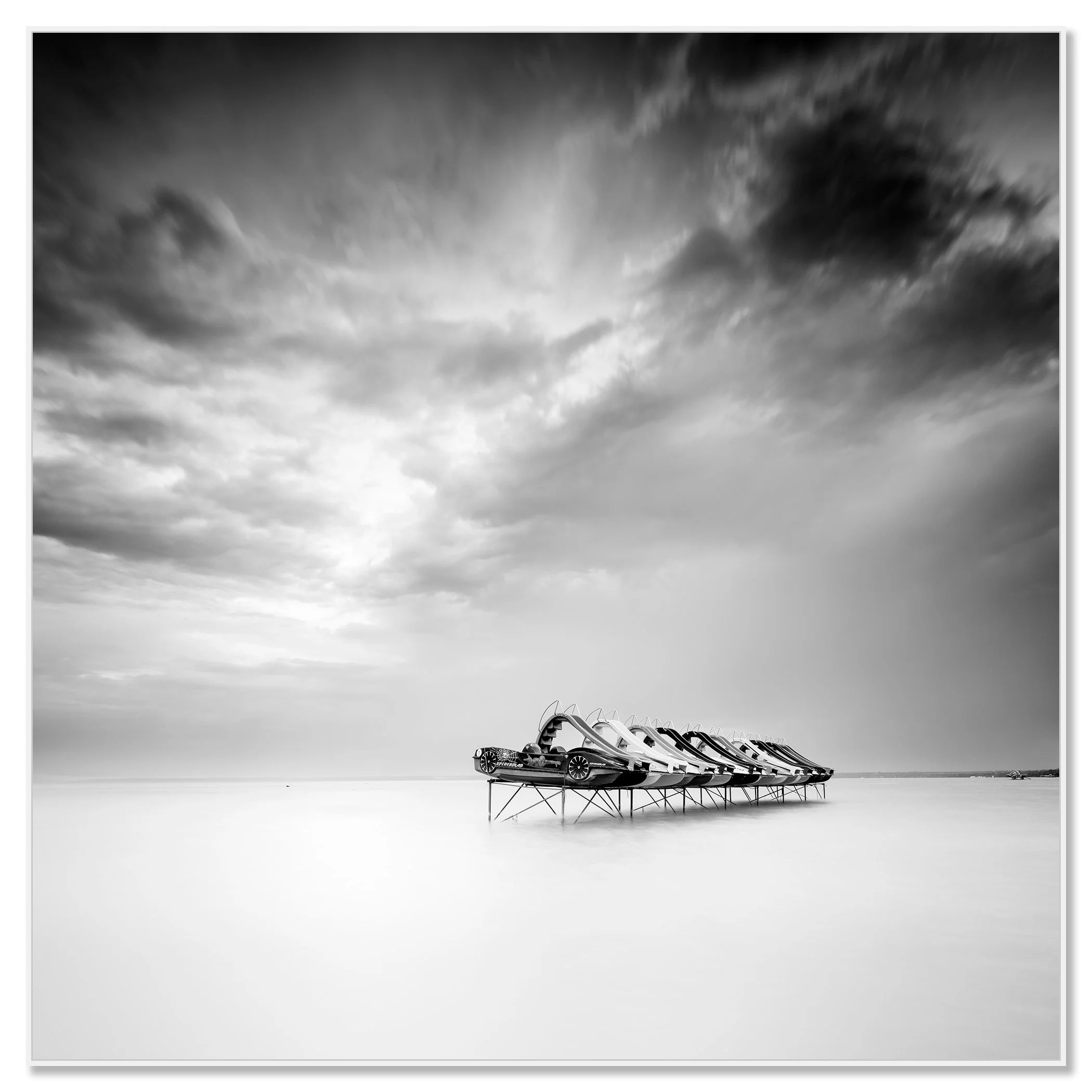 nd white long-exposure lake scene with pedal boats on stilts and a dramatic cloudy sky – framed ArtBox white