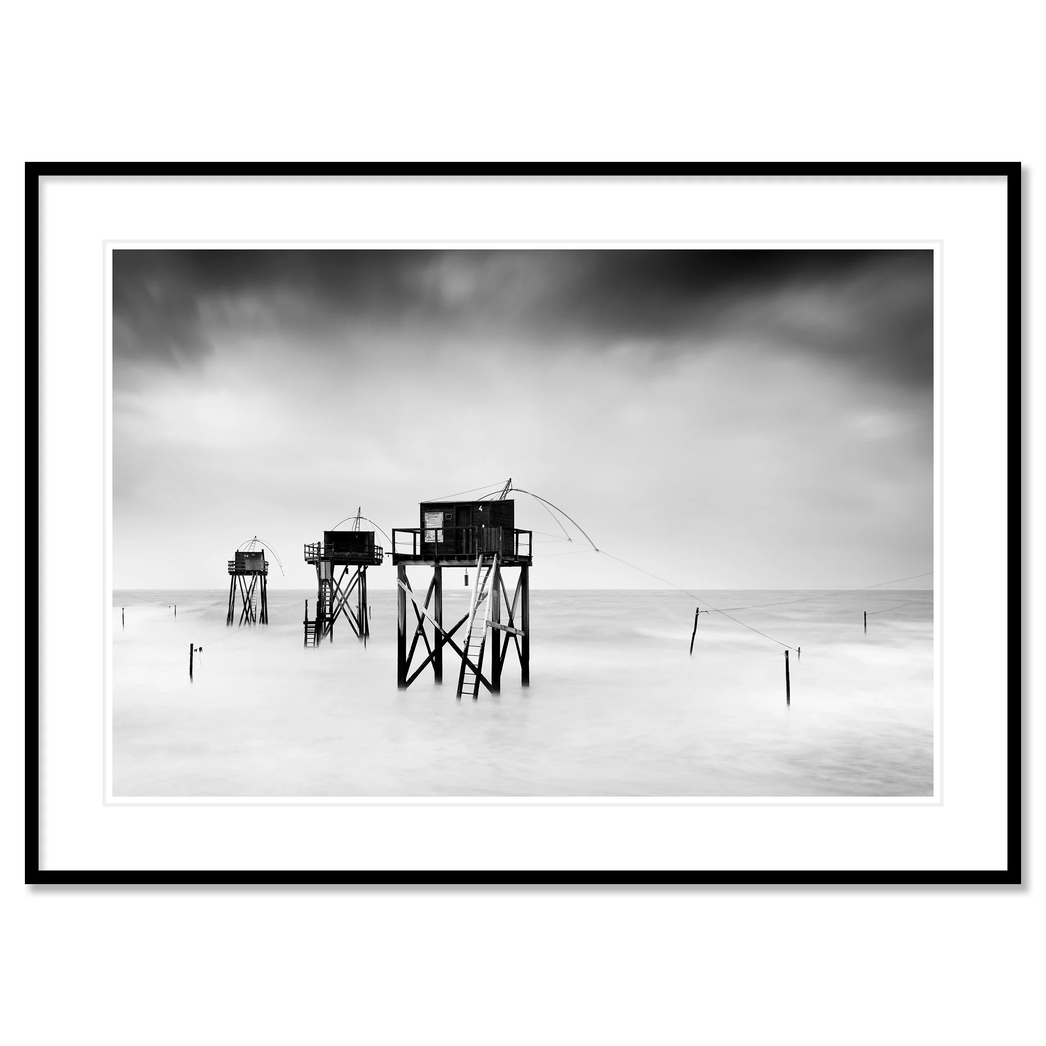 Monochrome long-exposure seascape with wooden fishing huts on stilts and misty water, Classic framed black