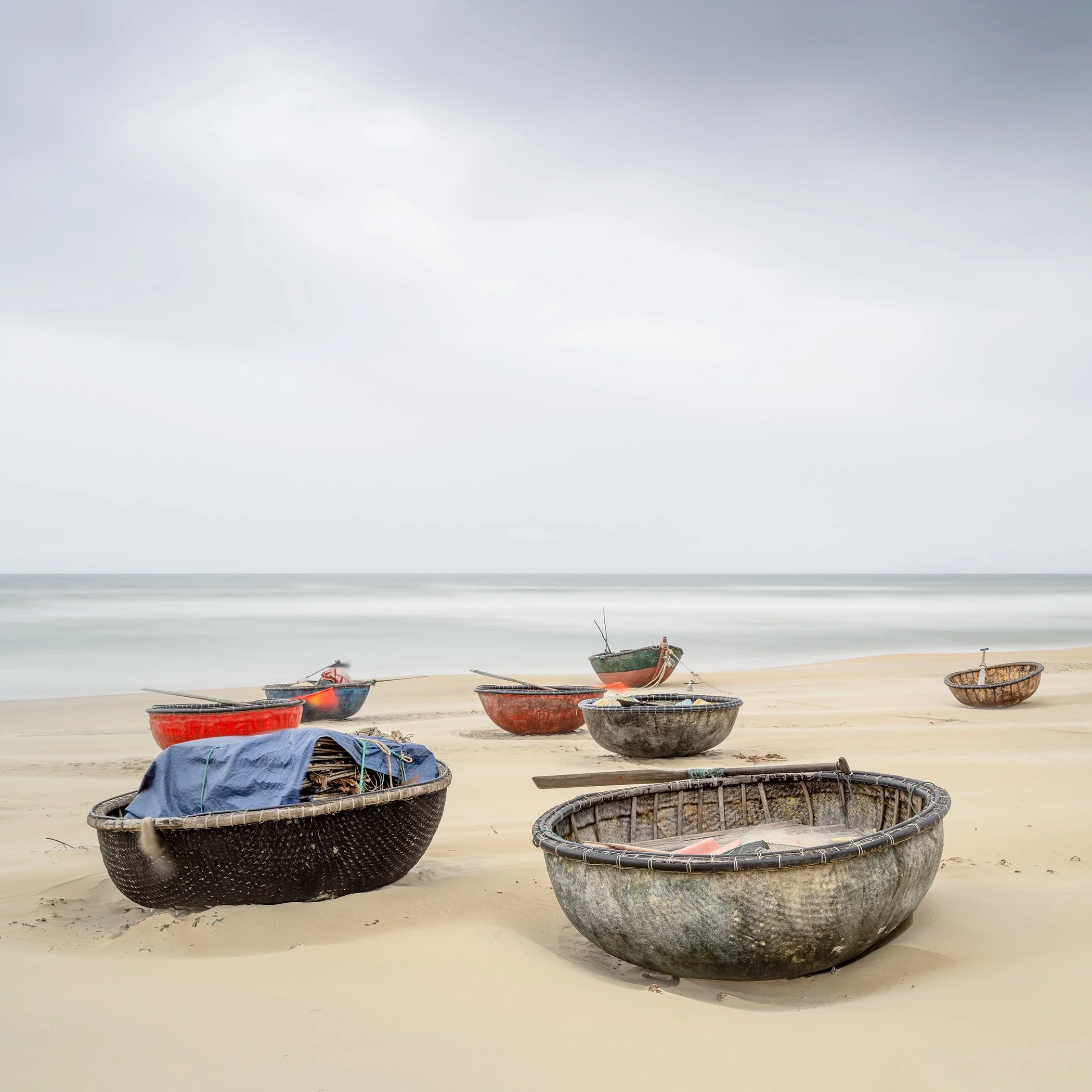 Coconut Boat Study 1, Vietnamese basket boats resting on a quiet sandy beach beside the sea in Vietnam, photographed by Gerald Berghammer.