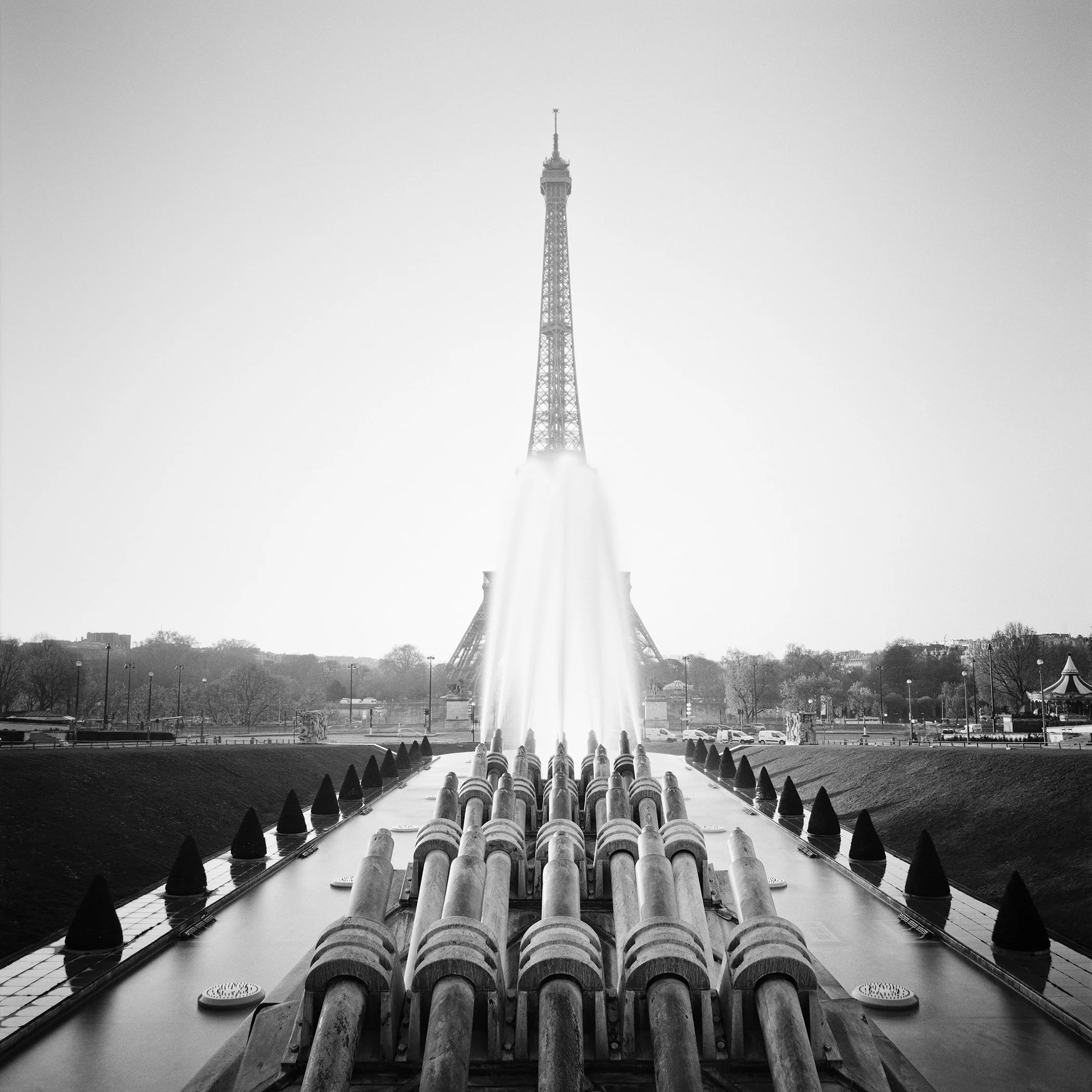 Black-and-white fine art photo by Gerald Berghammer of the Eiffel Tower seen through mist above the Trocadéro fountains in Paris.