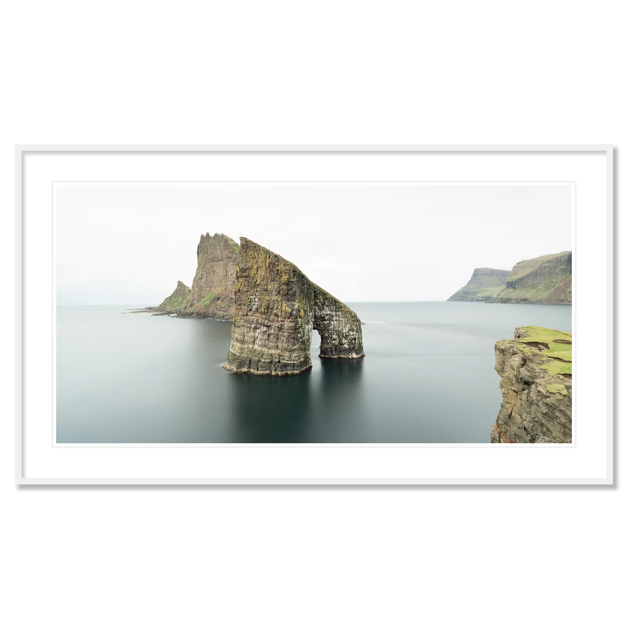 Gerald Berghammer - Color seascape panorama photography. Cliffs and sea stacks along a coastline under an overcast sky. Classic framed white