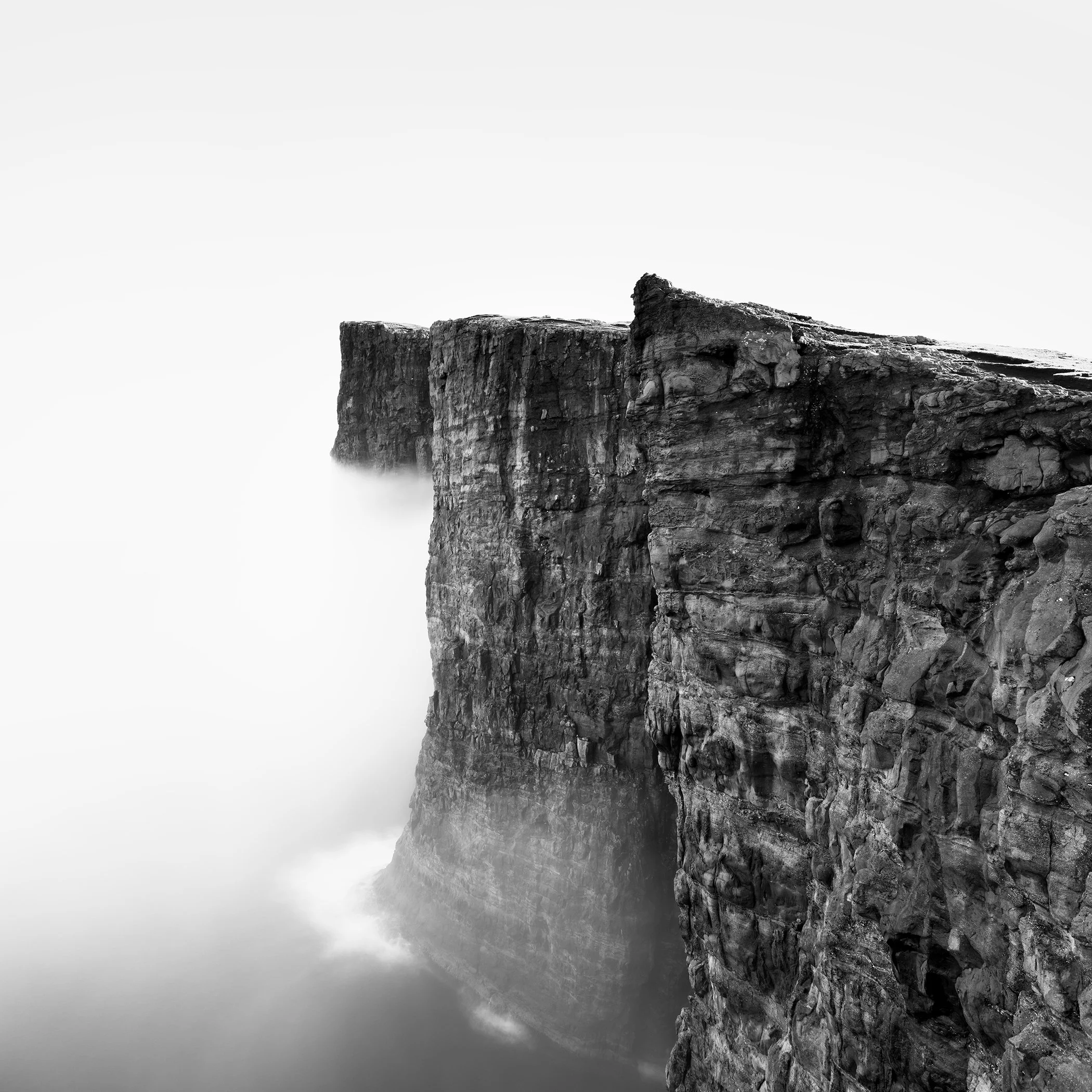 Foggy Slave Cliff Study 3 by Gerald Berghammer, minimalist black-and-white photograph of towering basalt sea cliffs rising through mist in the Faroe Islands.