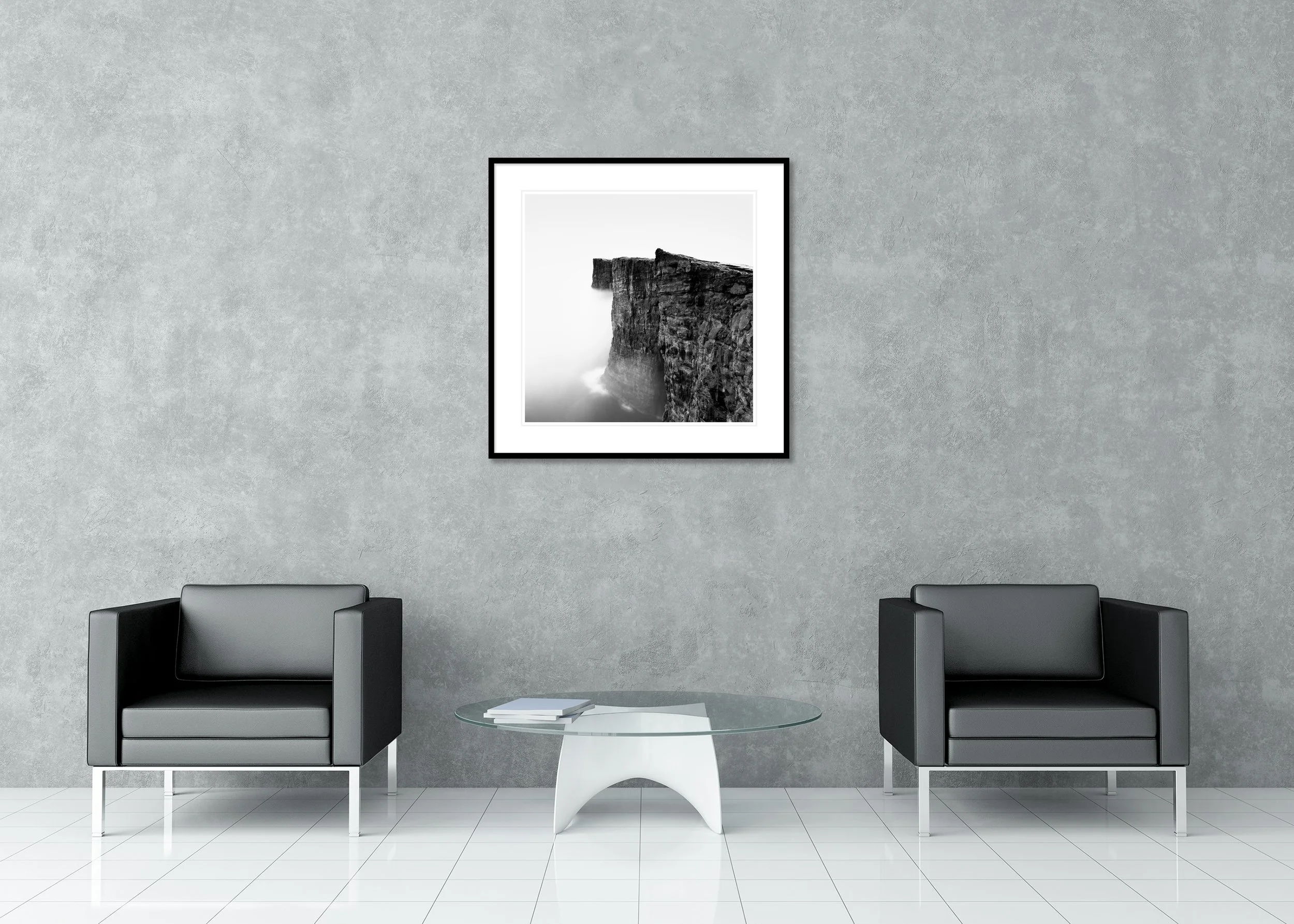 Black-and-white photo of steep coastal cliffs above the ocean, rugged rock textures fading into sea mist, as an archival pigment print in a classic frame with a passe-partout.