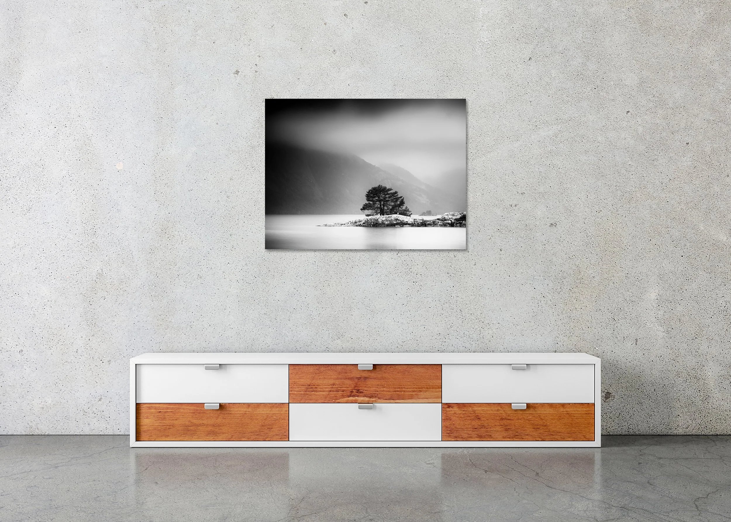 Atmospheric black and white lake scene with pine tree on a small island below fog-covered mountain slopes, photo print mounted to Dibond, frameless.