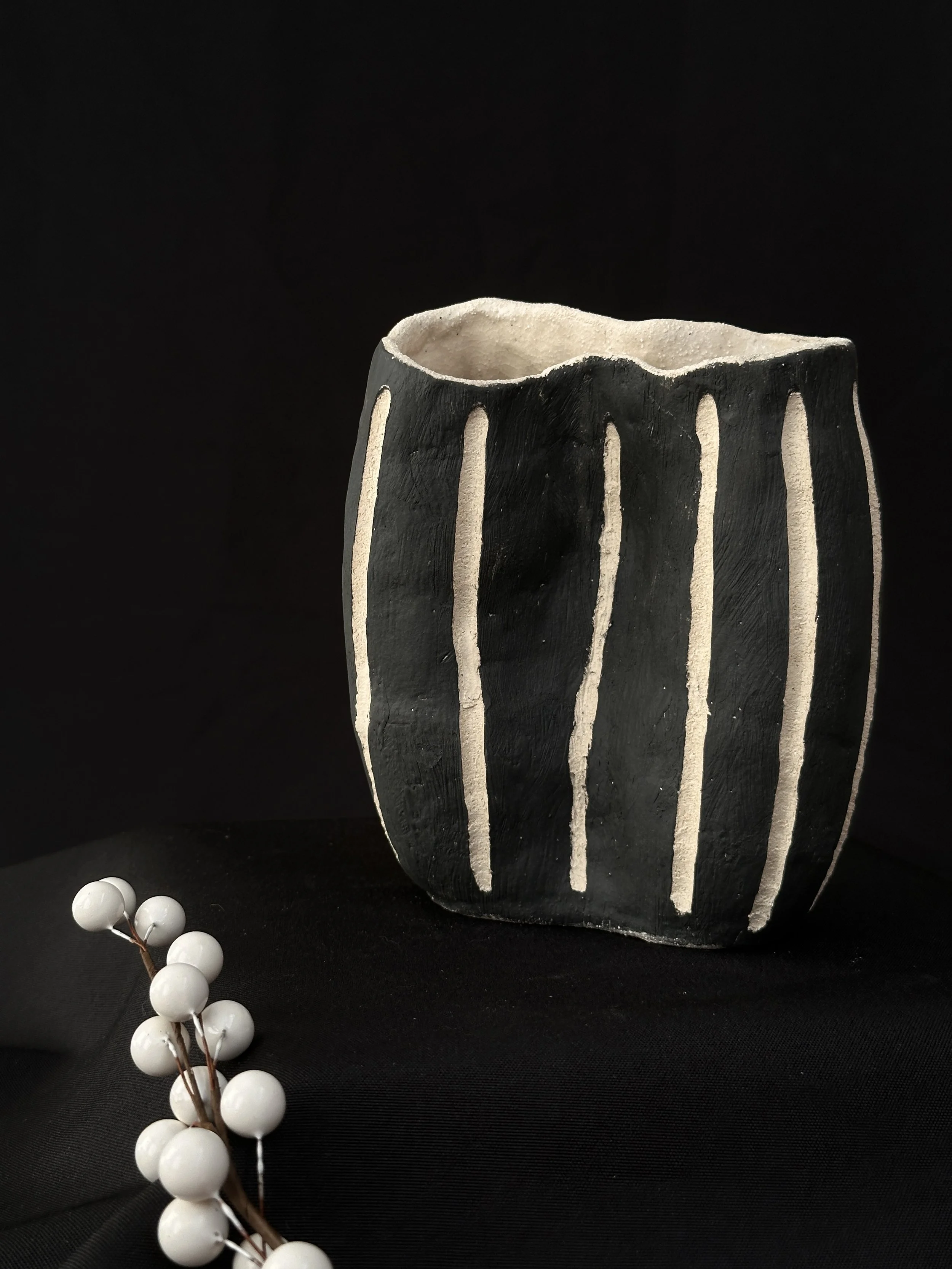 Vase black with cut away white stripes