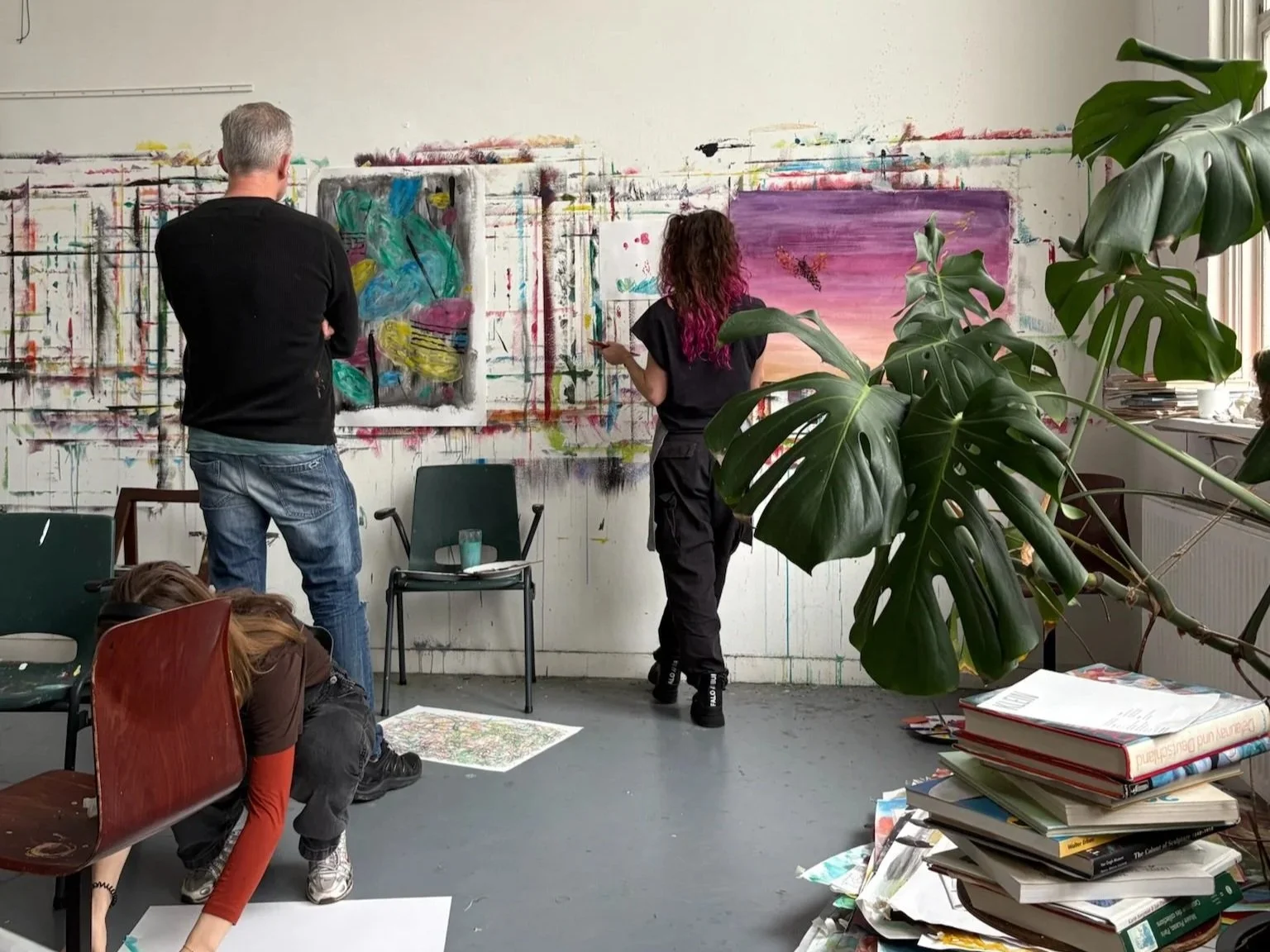 Mensen die schilderkunst maken in een kunststudio. Ze zijn een intuïtief process aangegaan en leren meer op hun intuïtie te vertrouwen door te schilderen. Ze schilderen samen, in een groep, maar in hun eigen process.