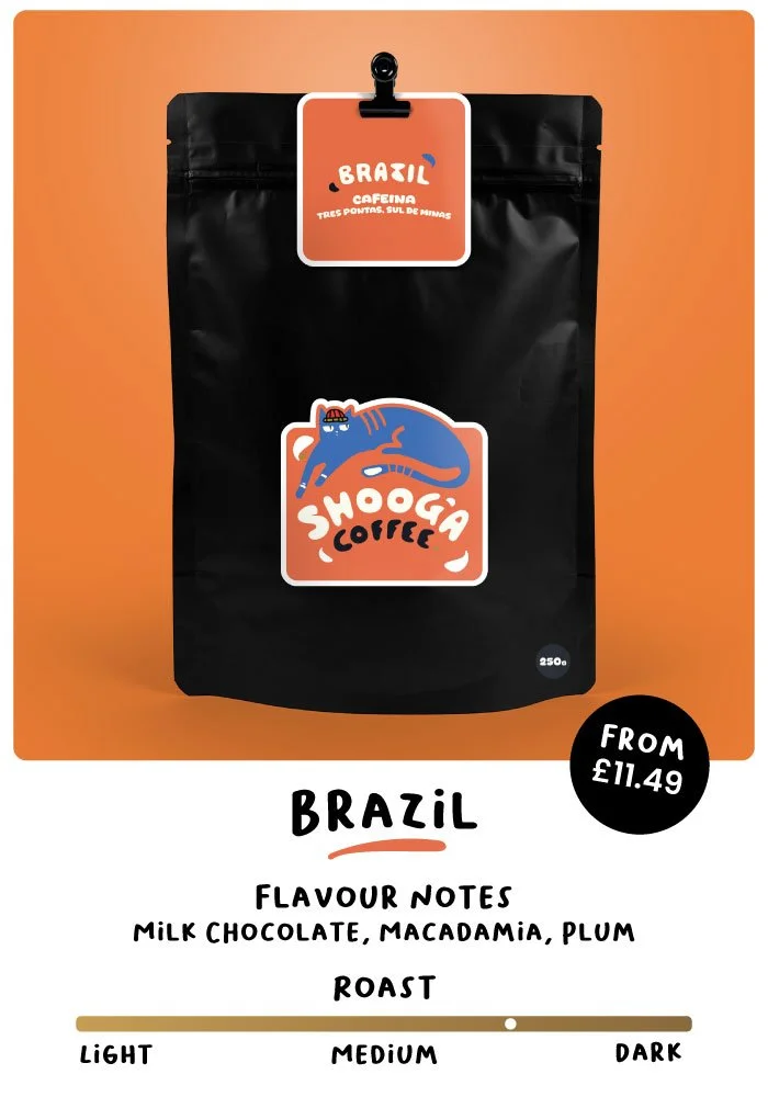 Coffee package labeled "Brazil Cafeina" with a design featuring a blue cat, brand name "Shooga Coffee," listed flavor notes of milk chocolate, macadamia, and plum, medium roast level, priced from £11.49. Available in 250g and 500g bags.