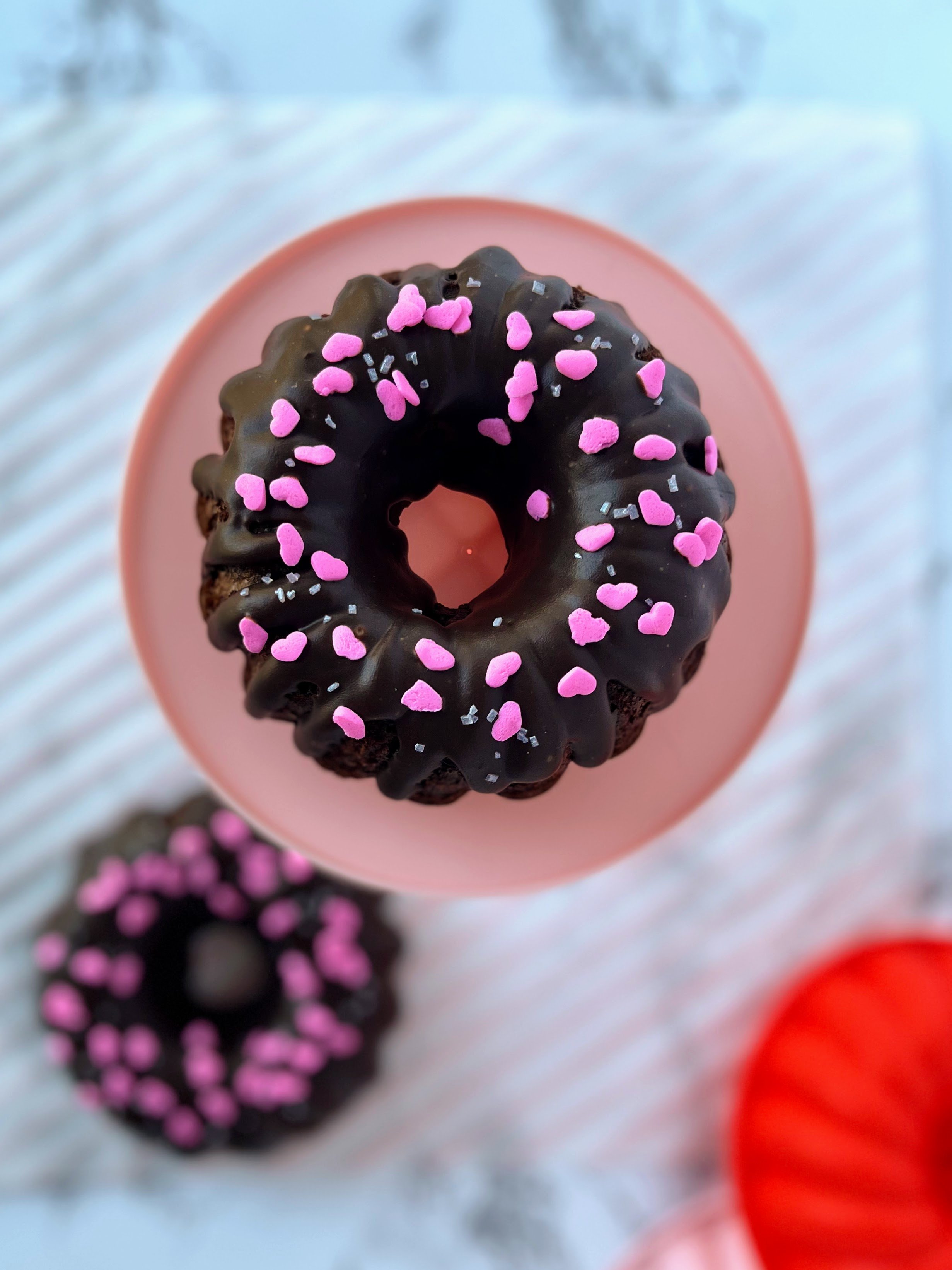 top down view of a chocolate bundt cake with heart sprinkles