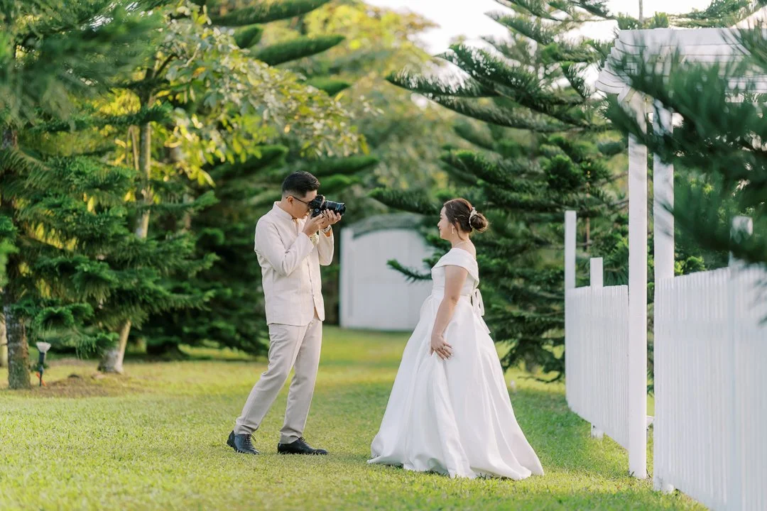 Photographer taking pictures of bride in garden setting