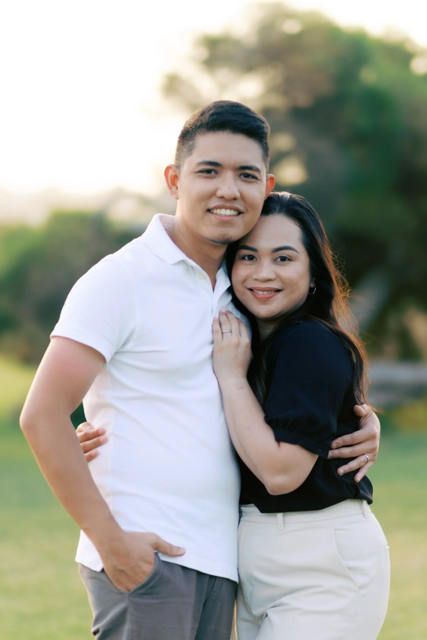 Man and woman embracing and smiling in a lush green park in Torquay, Geelong, Australia