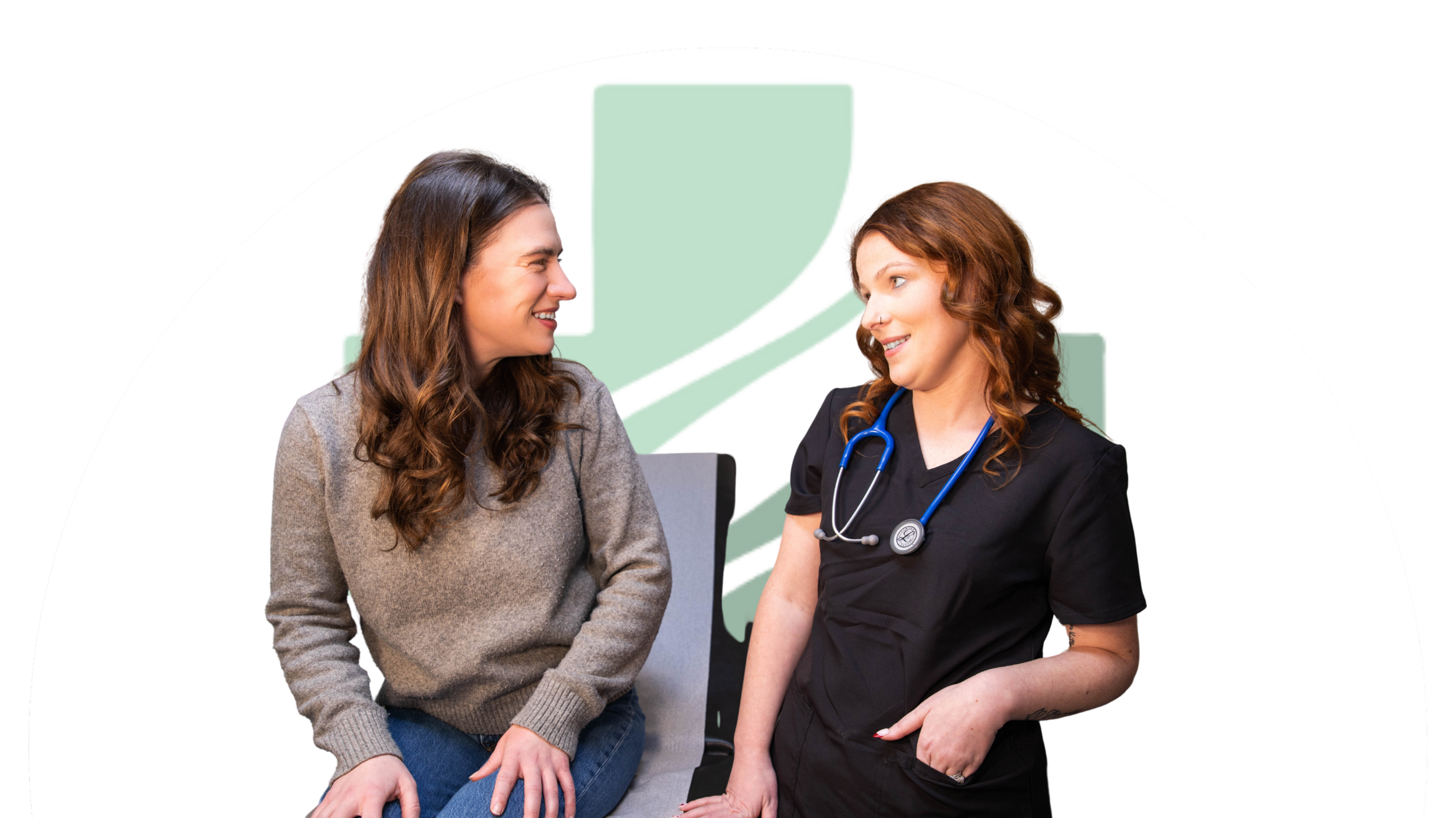 A female nurse consulting with a woman patient in a medical office.