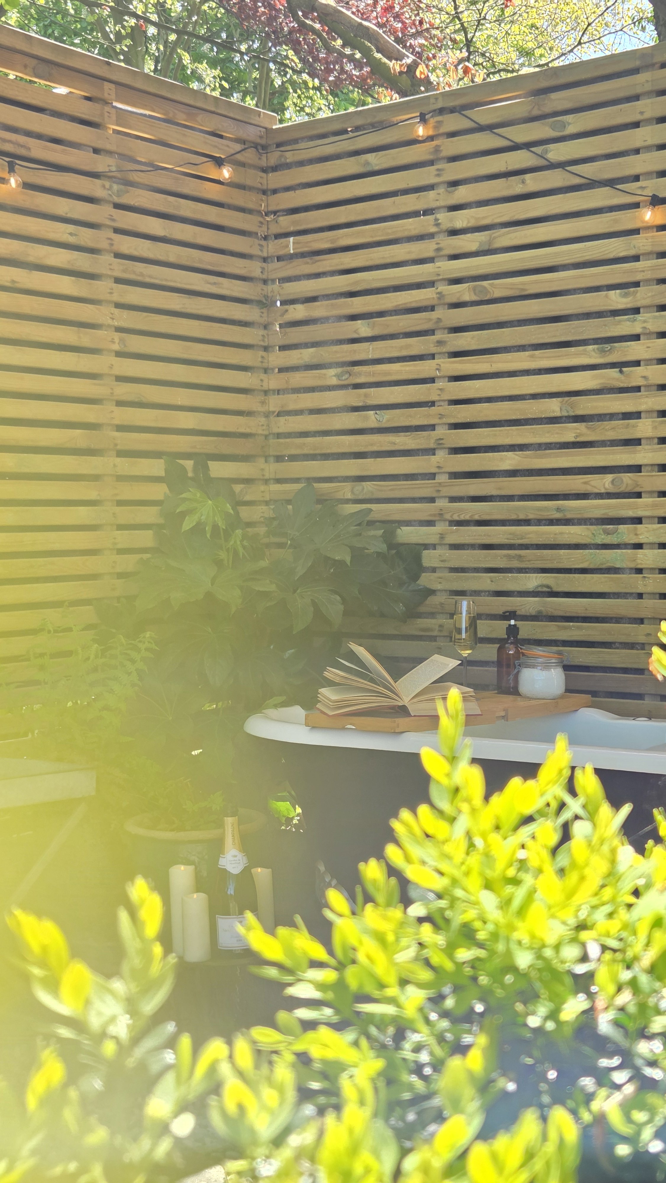 Outdoor cast-iron bath surrounded by woodland at The Lodge Burniston luxury cabin on the Yorkshire Coast.