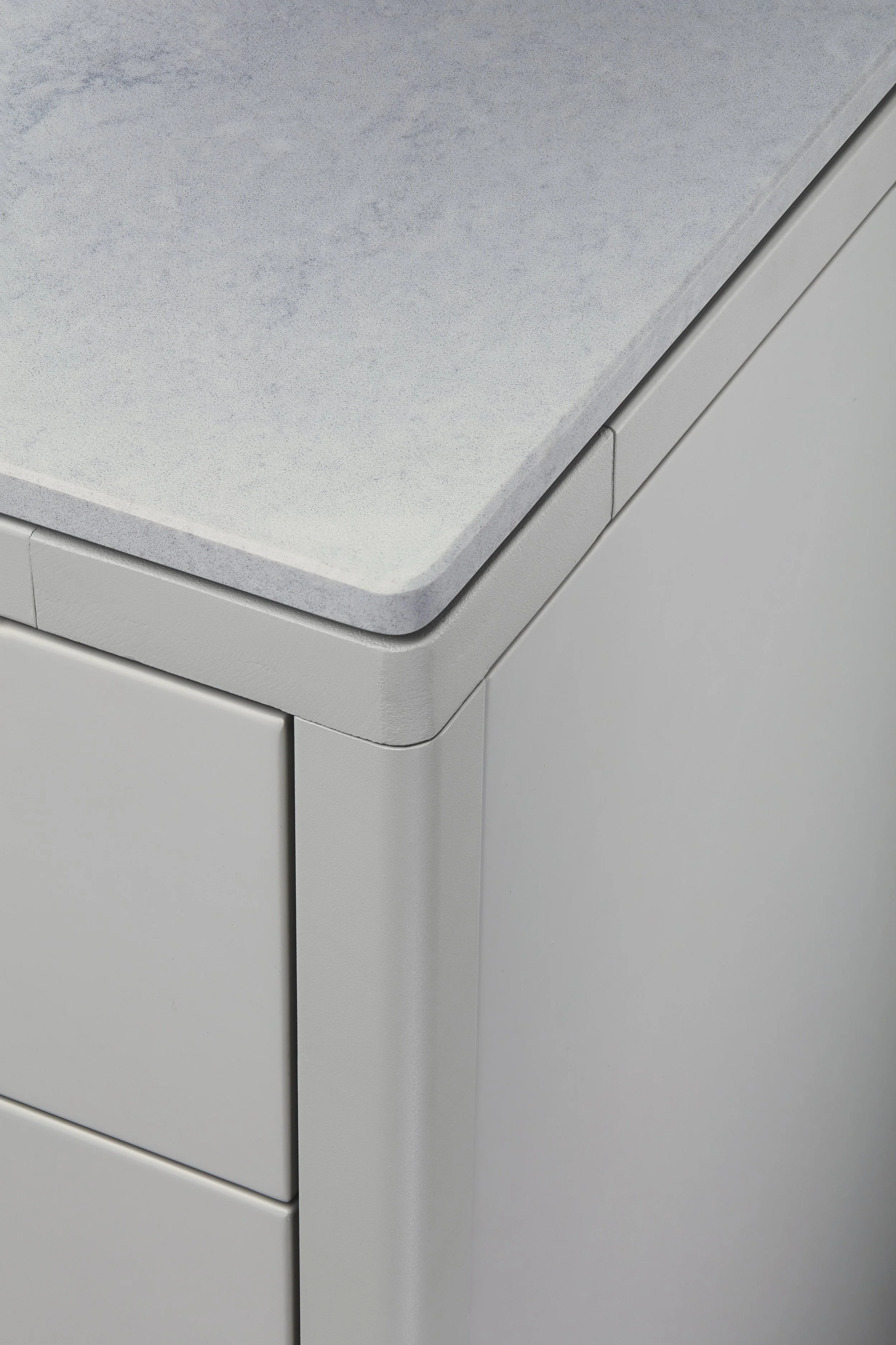 Close-up of a modern, light gray washing machine with a metallic top panel and a frontal lid.