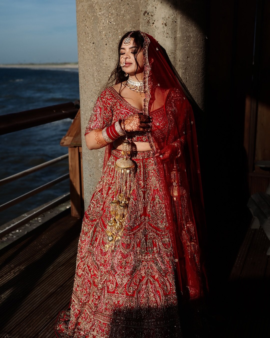 Golden hour, a sea breeze, and the iconic Scheveningen Pier set the scene for Shivika&rsquo;s bridal portraits &mdash; and the result was pure magic. The soft light wrapped around her like a veil, while the ocean stretched endlessly behind her, creat