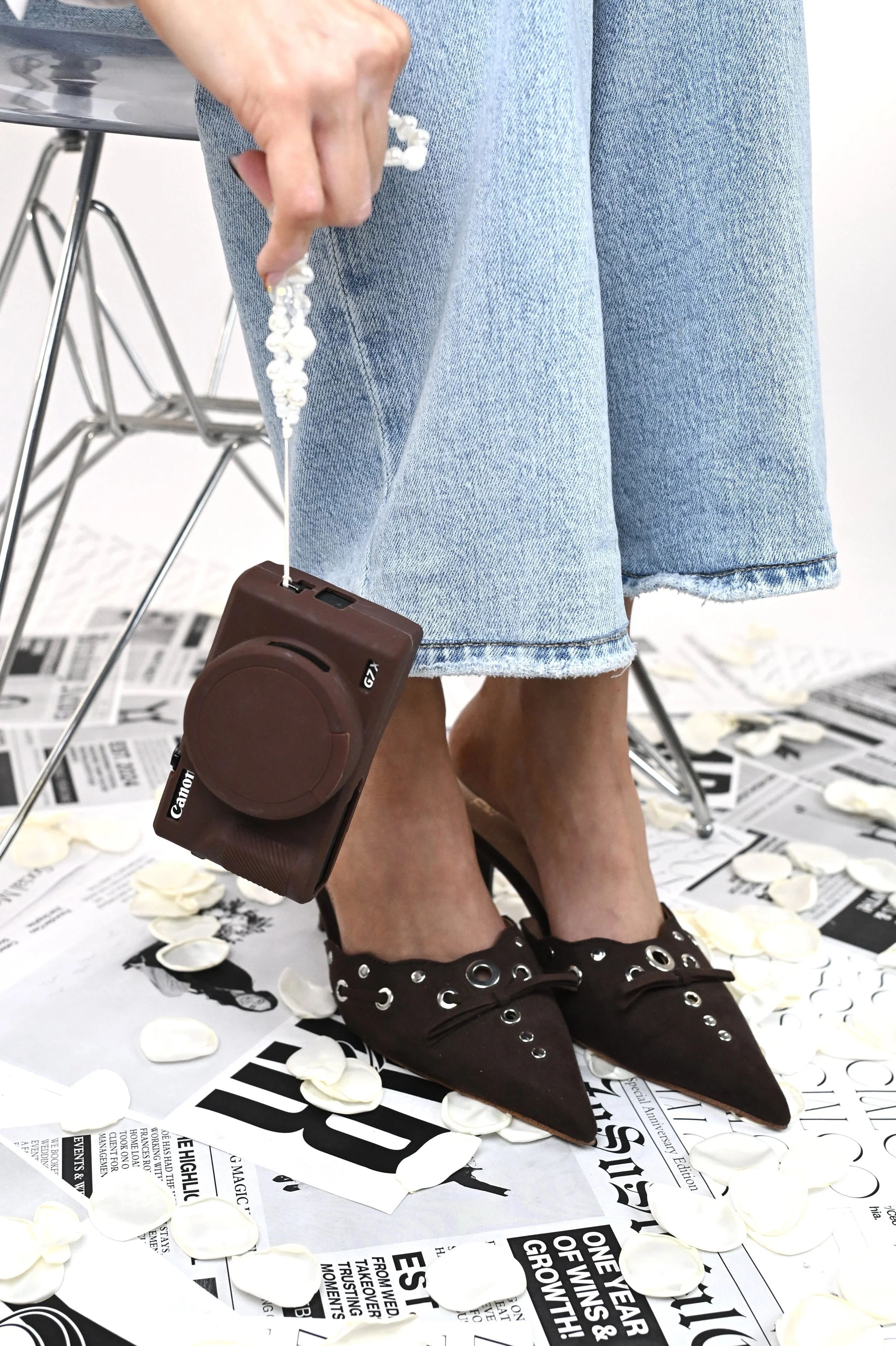 Empty beach with blue umbrellas arranged in rows, white sand, ocean waves, and a clear blue sky.