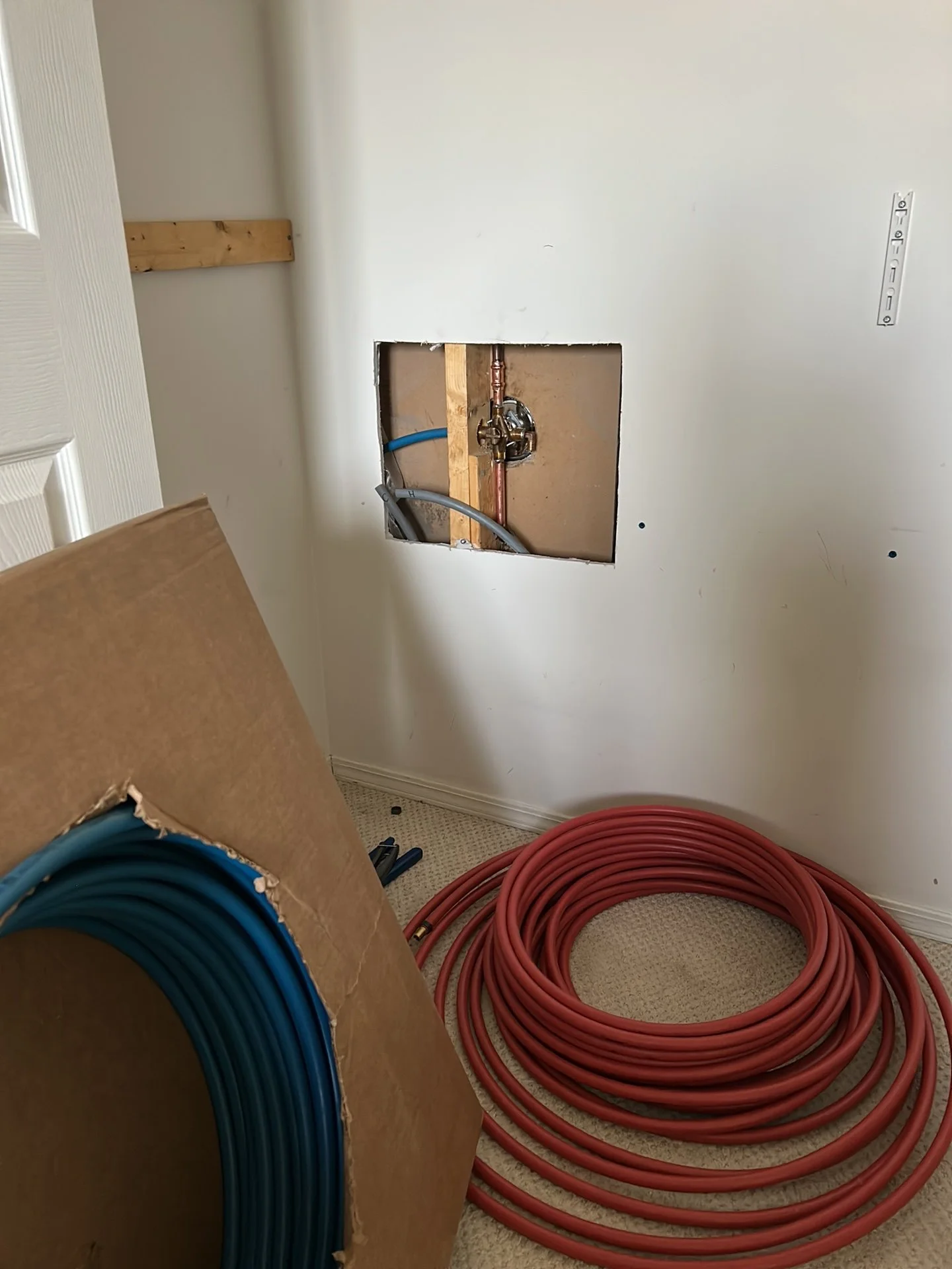Wall openings exposing Poly-B waterlines during a whole-home repiping project in Edmonton