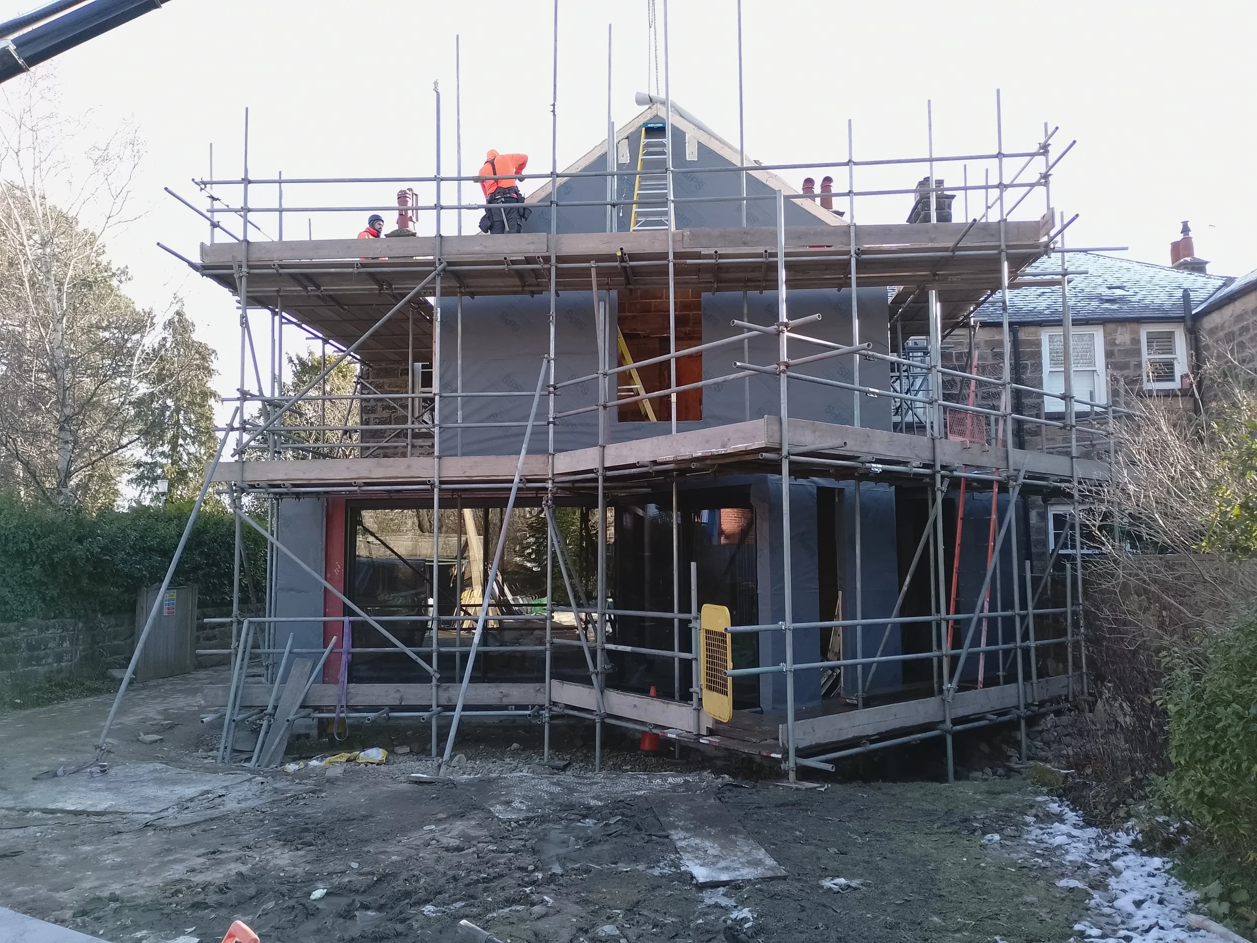Construction workers on scaffolding assembling an SIPs extension in Harrogate