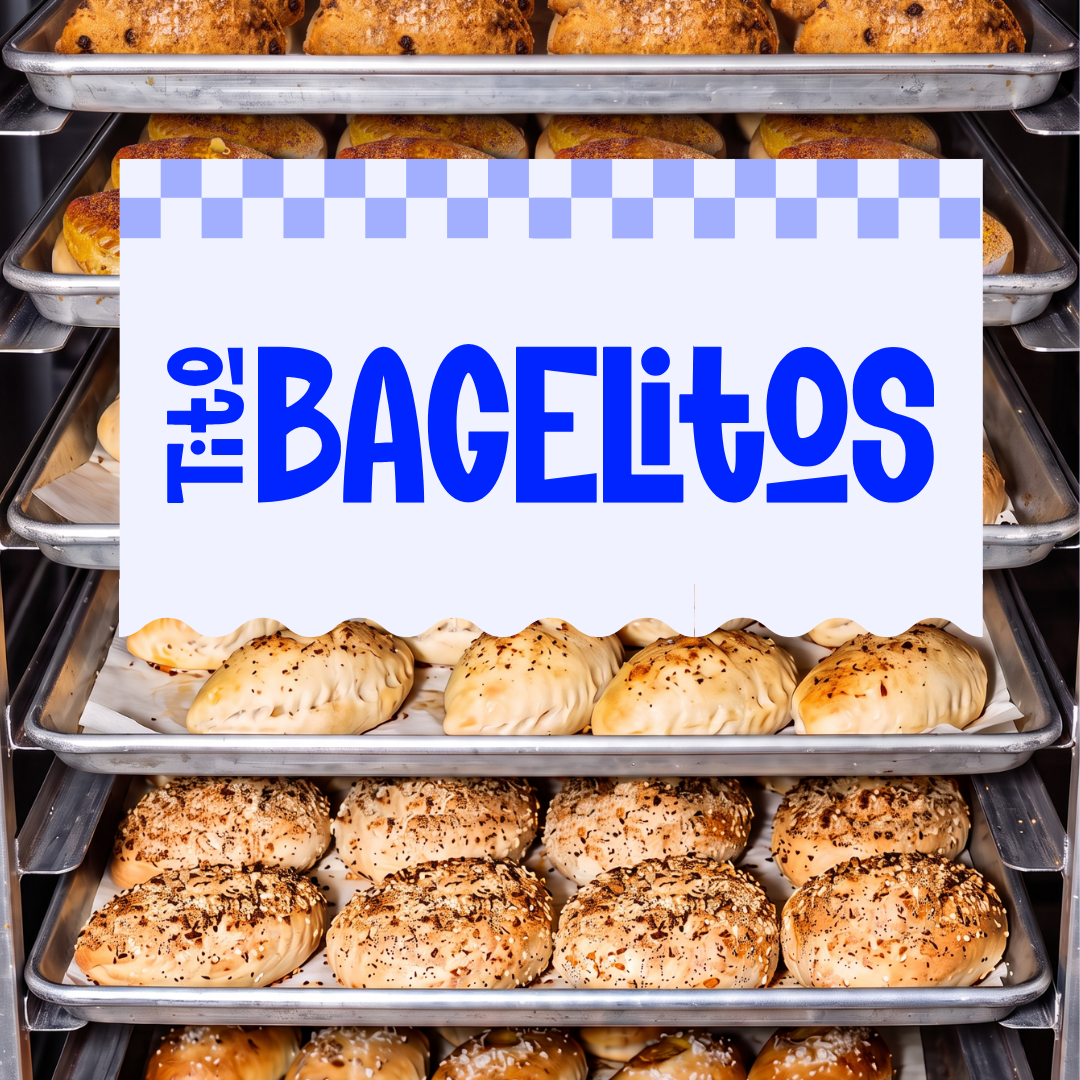 Display of various bagel varieties in a bakery display case with a sign reading 'This is the Bagelitos'.