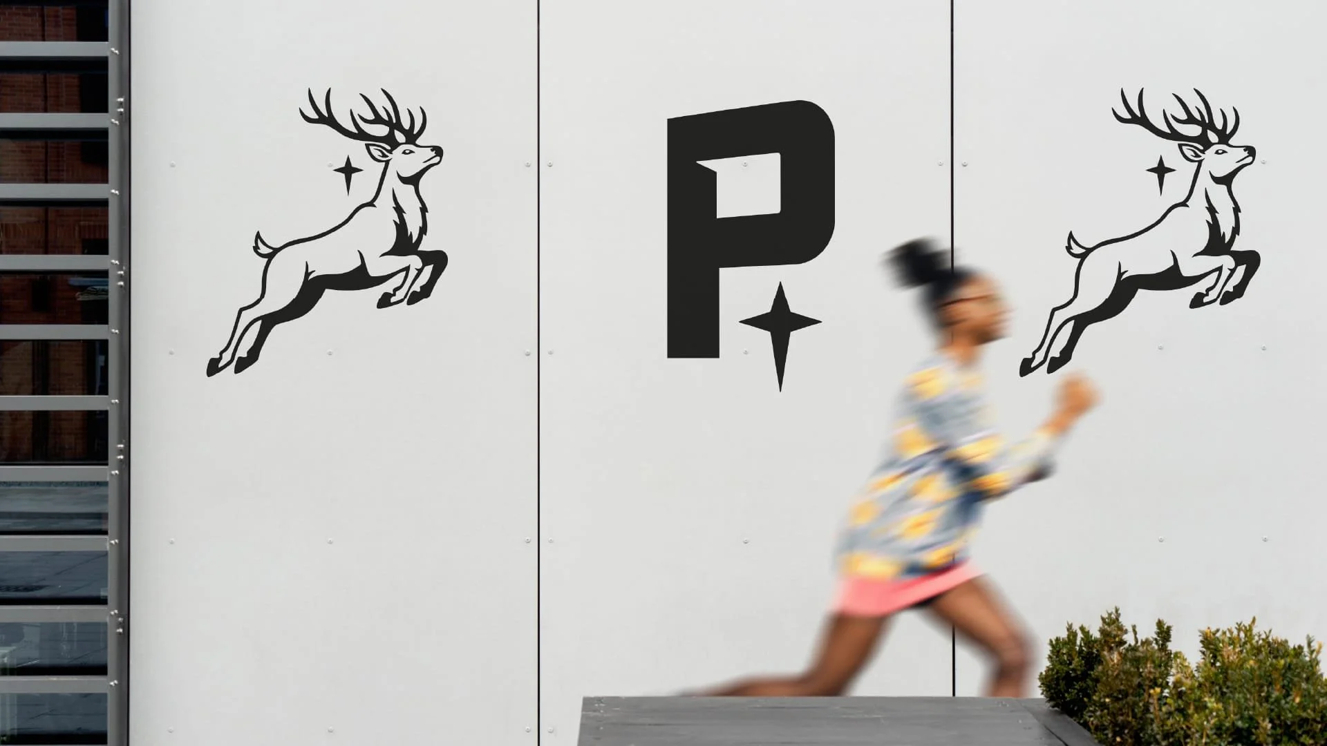 Girl runs past Pilgrims branded wall