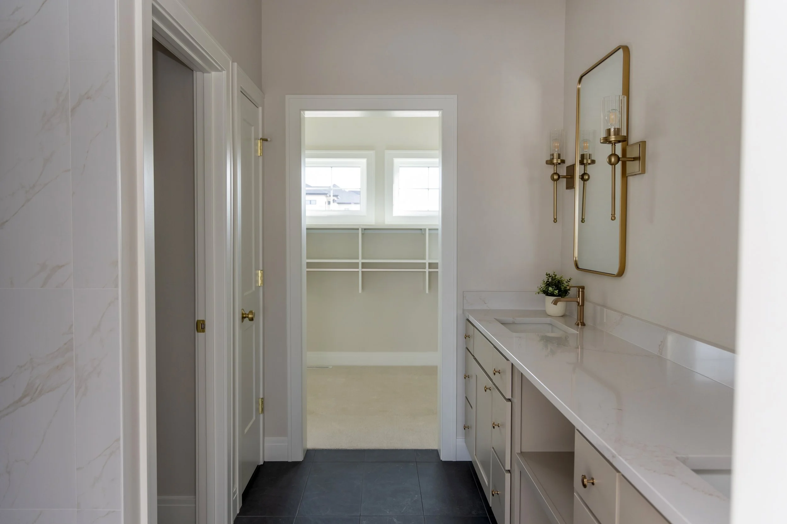 Zoomed out image of a walk through bathroom and closet