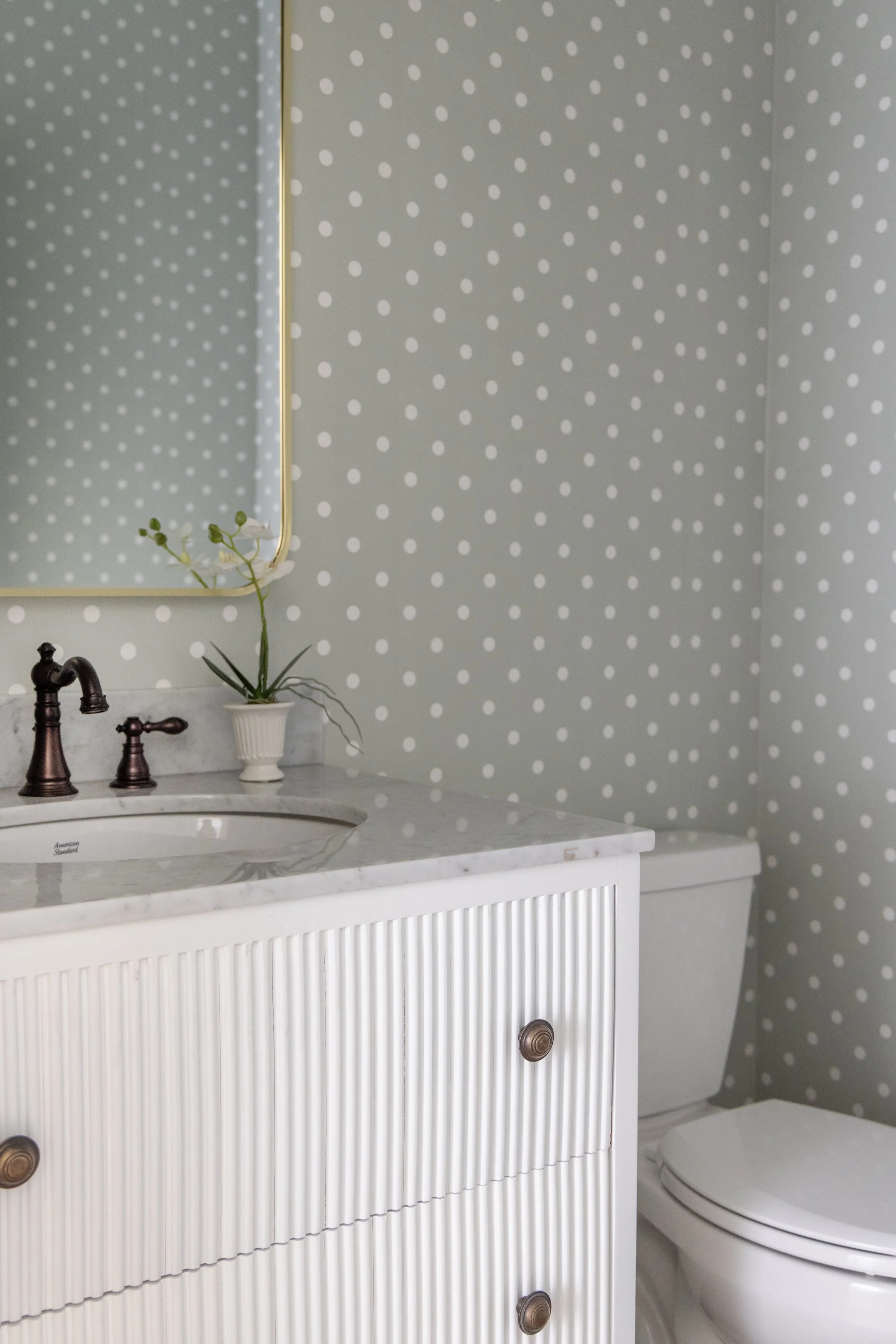Small bathroom with mint polkdot wallpaper
