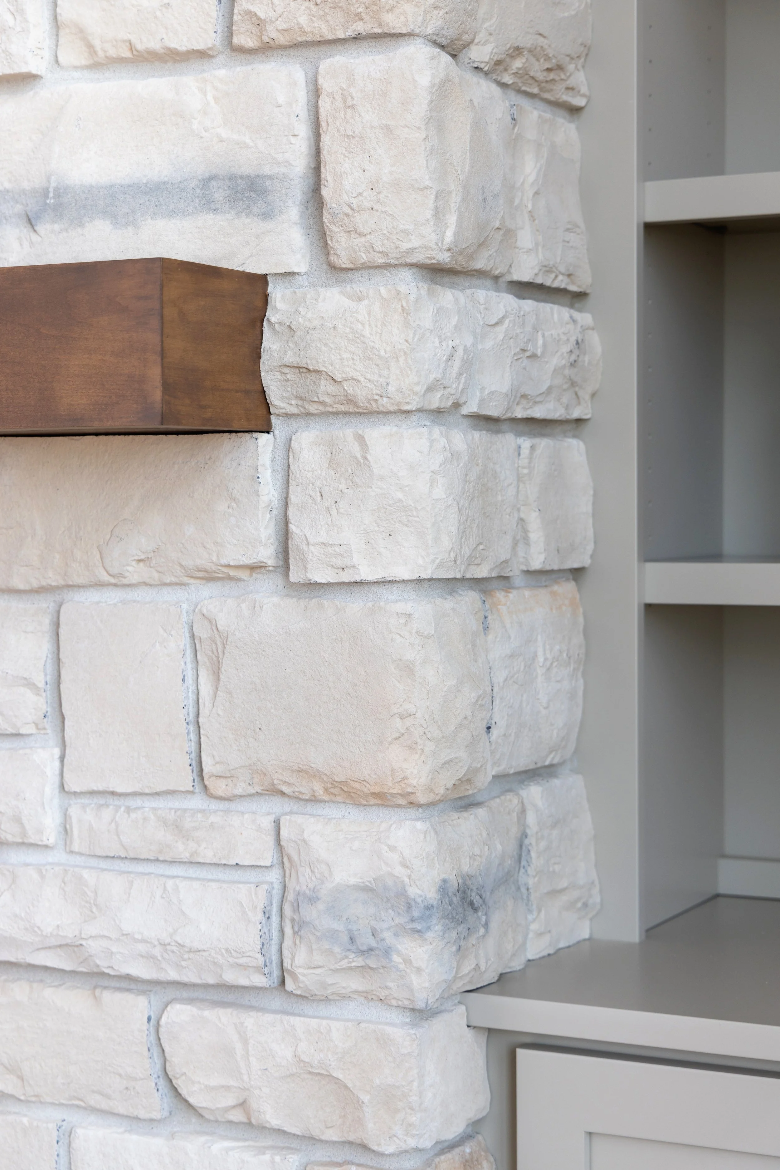 Close up of light brick fireplace and built-in sheving