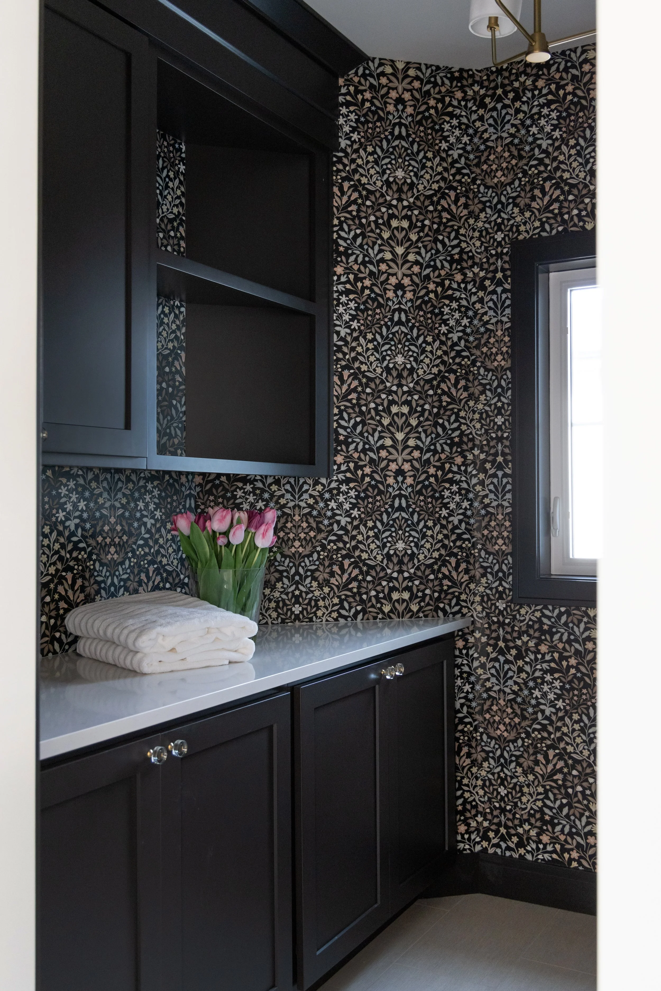 Dark floral wallpaper with black cabinets